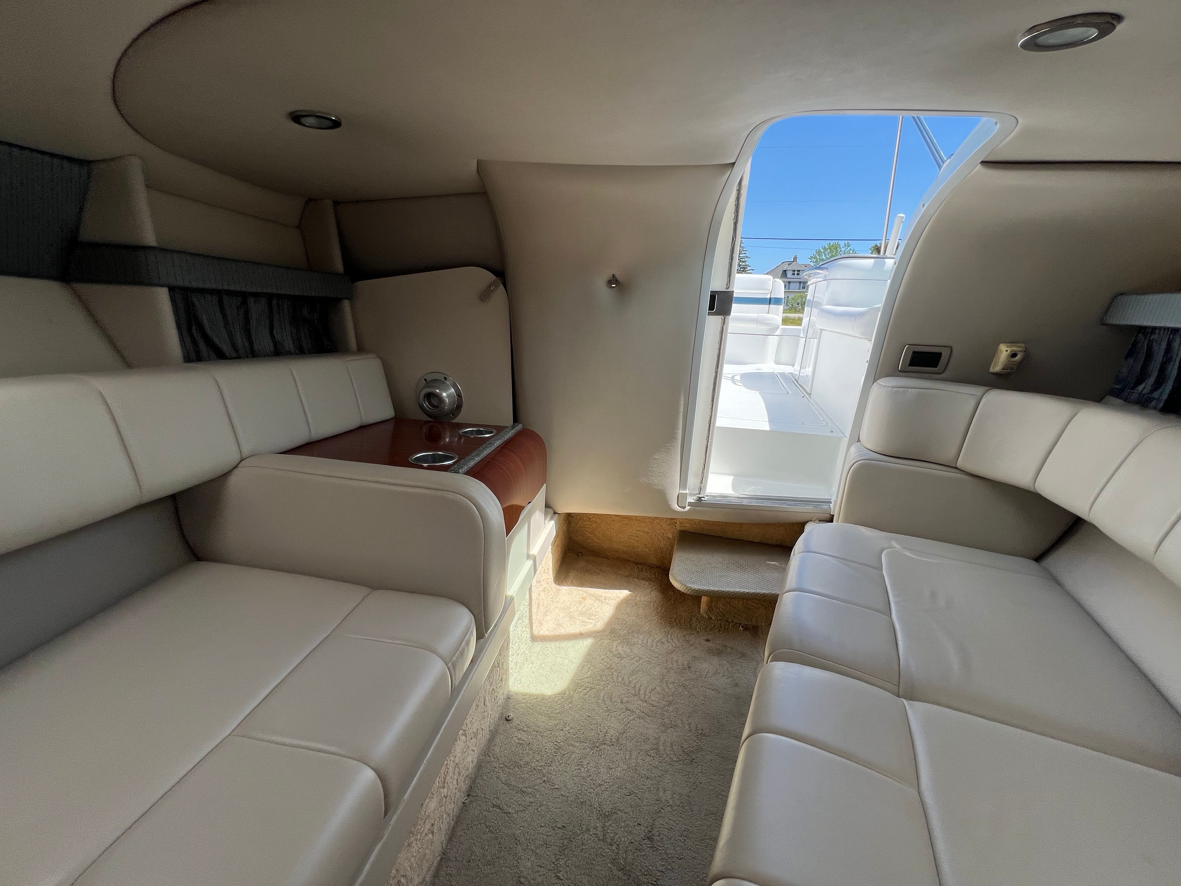 Interior of the 2005 Formula 260 Sun Sport with cream upholstery and access to the deck.