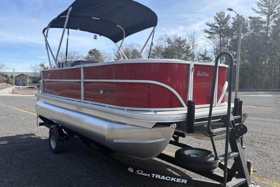 2026 Sun Tracker Party Barge 18 DLX pontoon boat on trailer, parked outdoors.