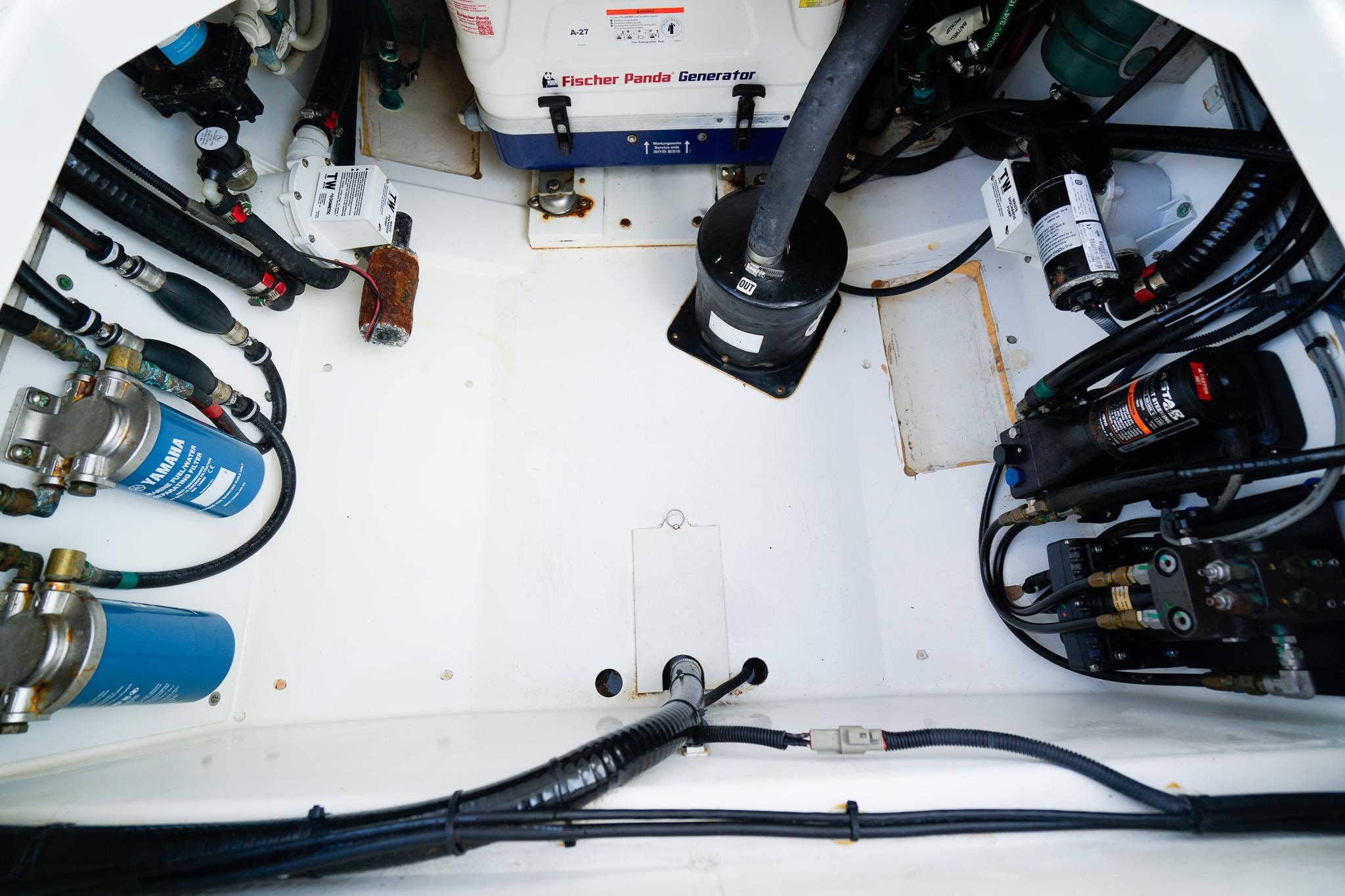Engine compartment of a 2020 Pursuit OS 325 Offshore boat with visible generator and components.