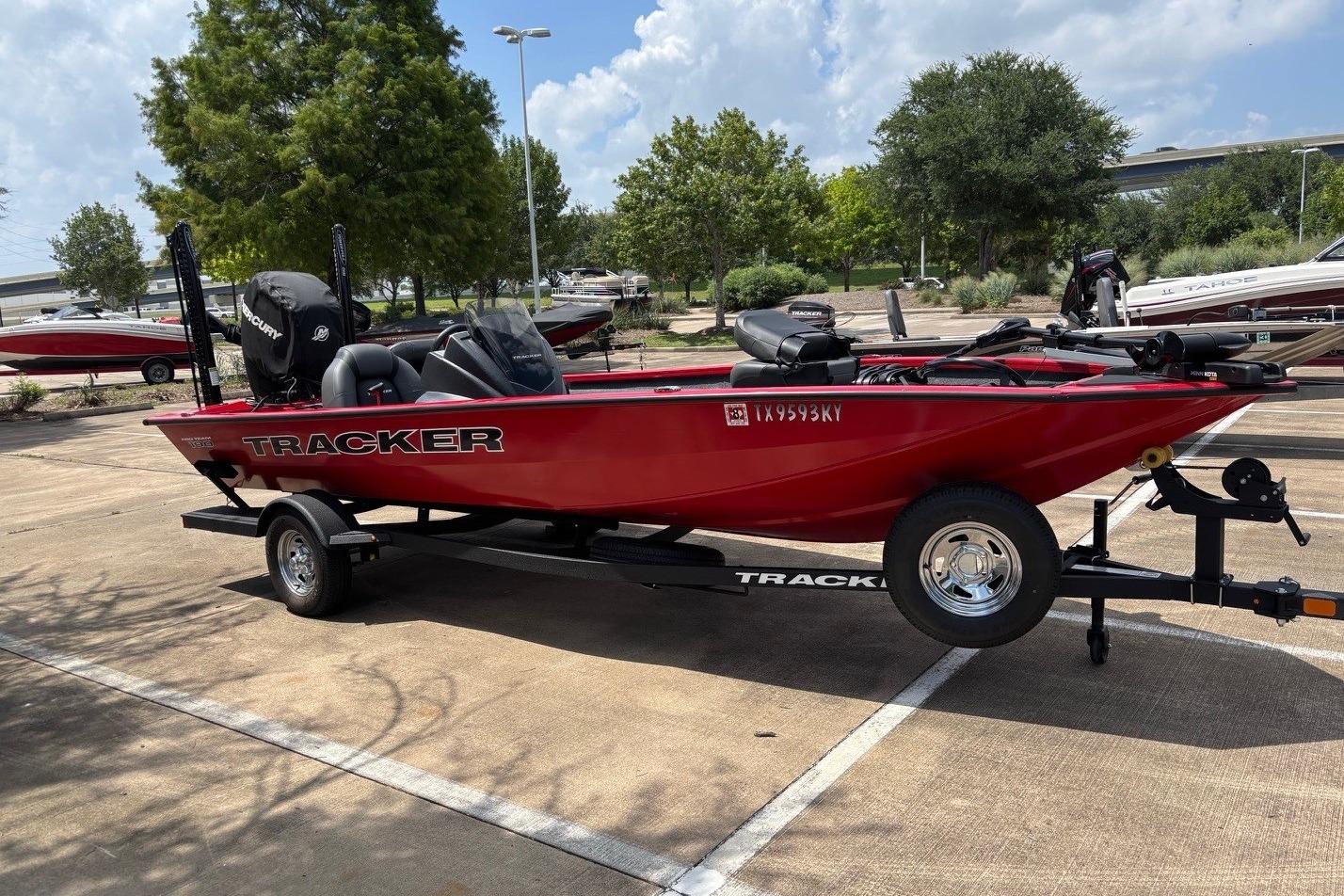Red 2026 Tracker Pro Team 190 TX boat on trailer in parking lot.
