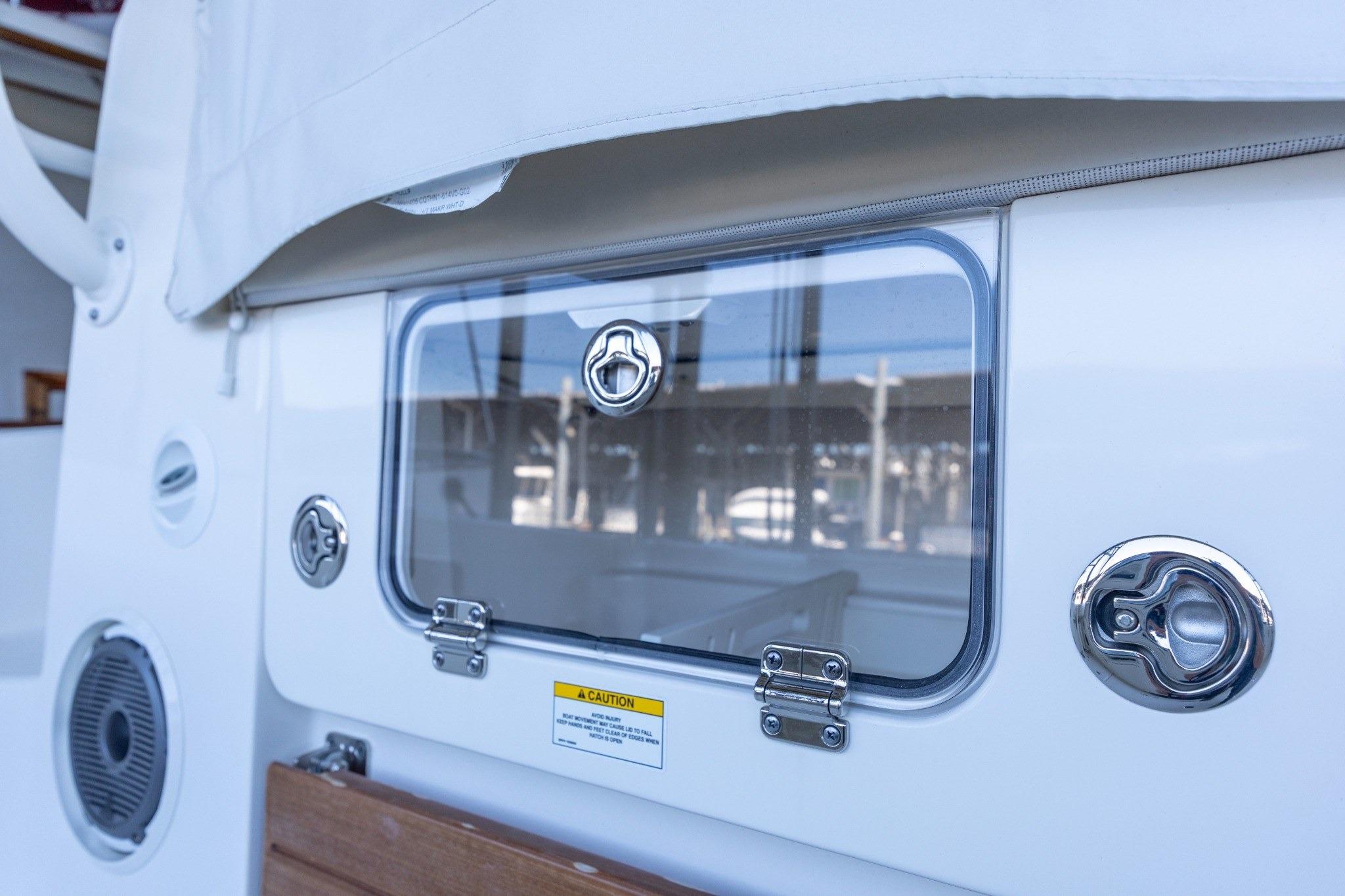 2023 Boston Whaler 405 Conquest boat hatch with chrome fittings and caution label.