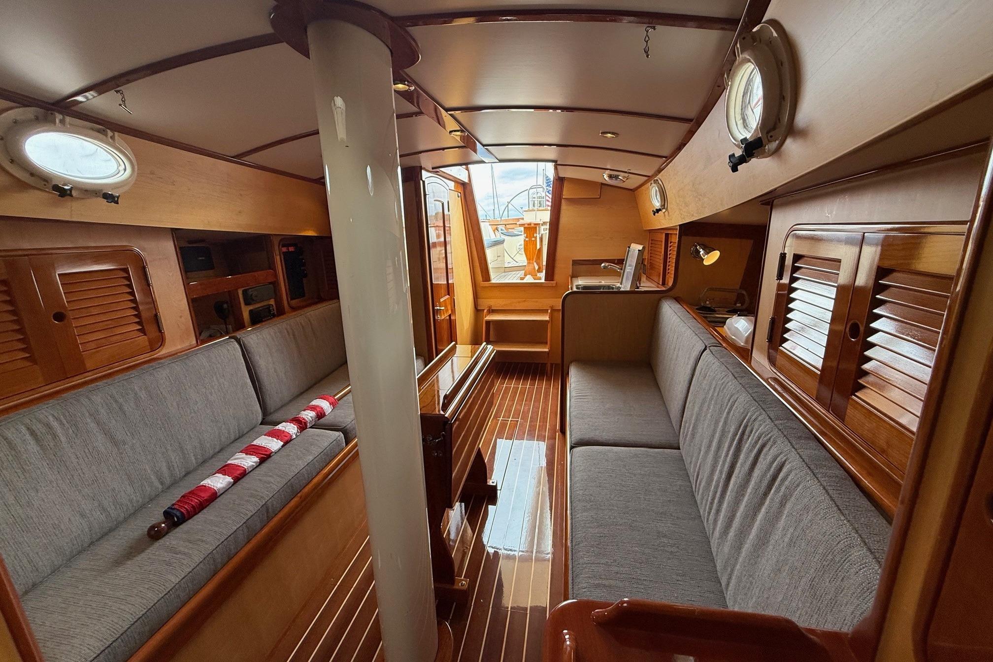 Interior of 2015 Hinckley DS 42 yacht with wooden finish and cozy seating.