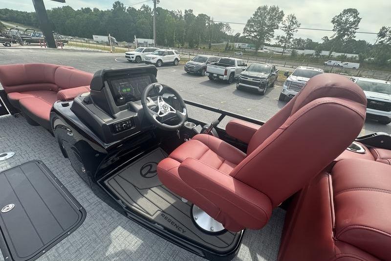 Luxurious 2026 Regency 230 DL boat interior with red seating and modern dashboard.