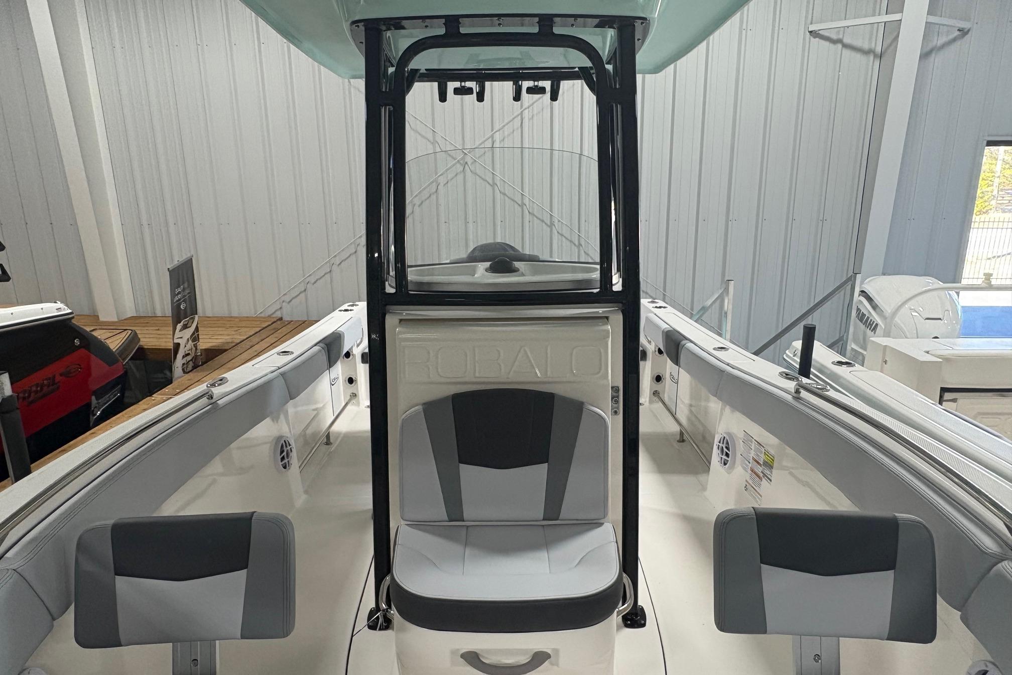 2025 Robalo R232 Explorer boat interior with seating and console in showroom.