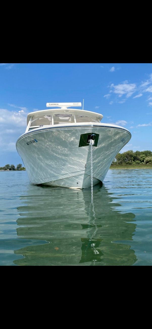 2023 Cobia 330 boat anchored on calm water.