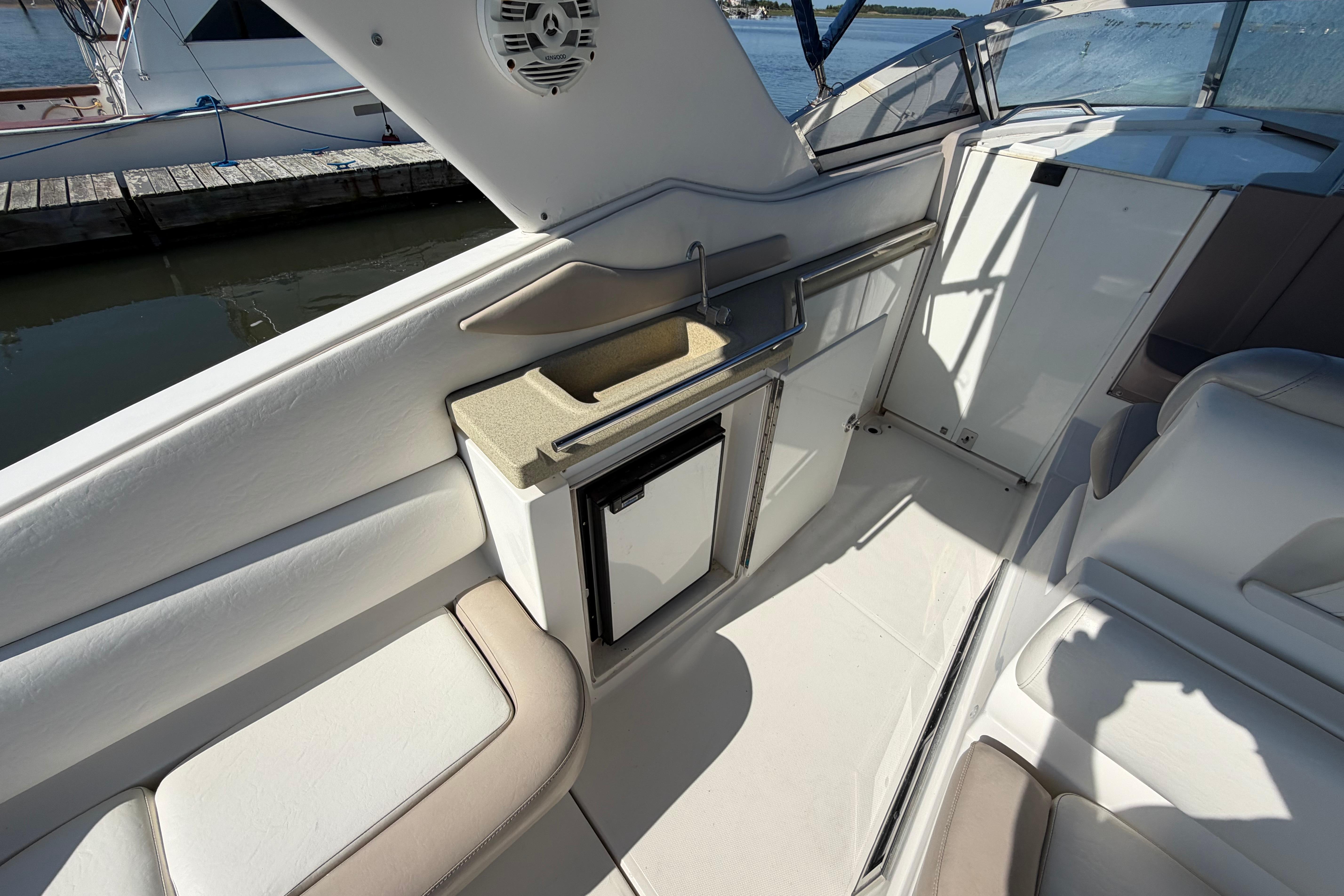 2003 Regal Commodore 3260 boat interior with seating, mini fridge, and sink.