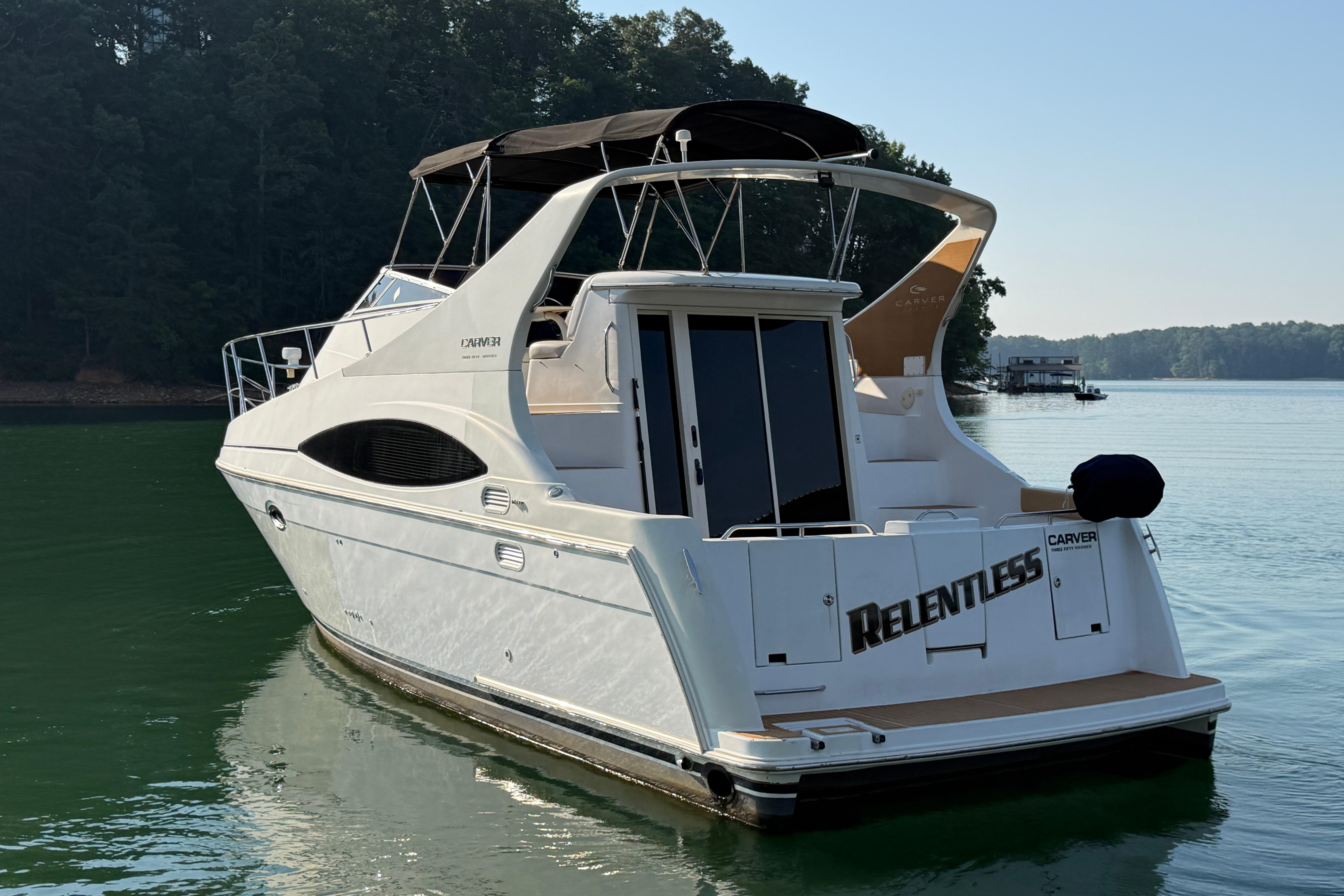 2003 Carver 350 Mariner yacht named "Relentless" on a serene lake.
