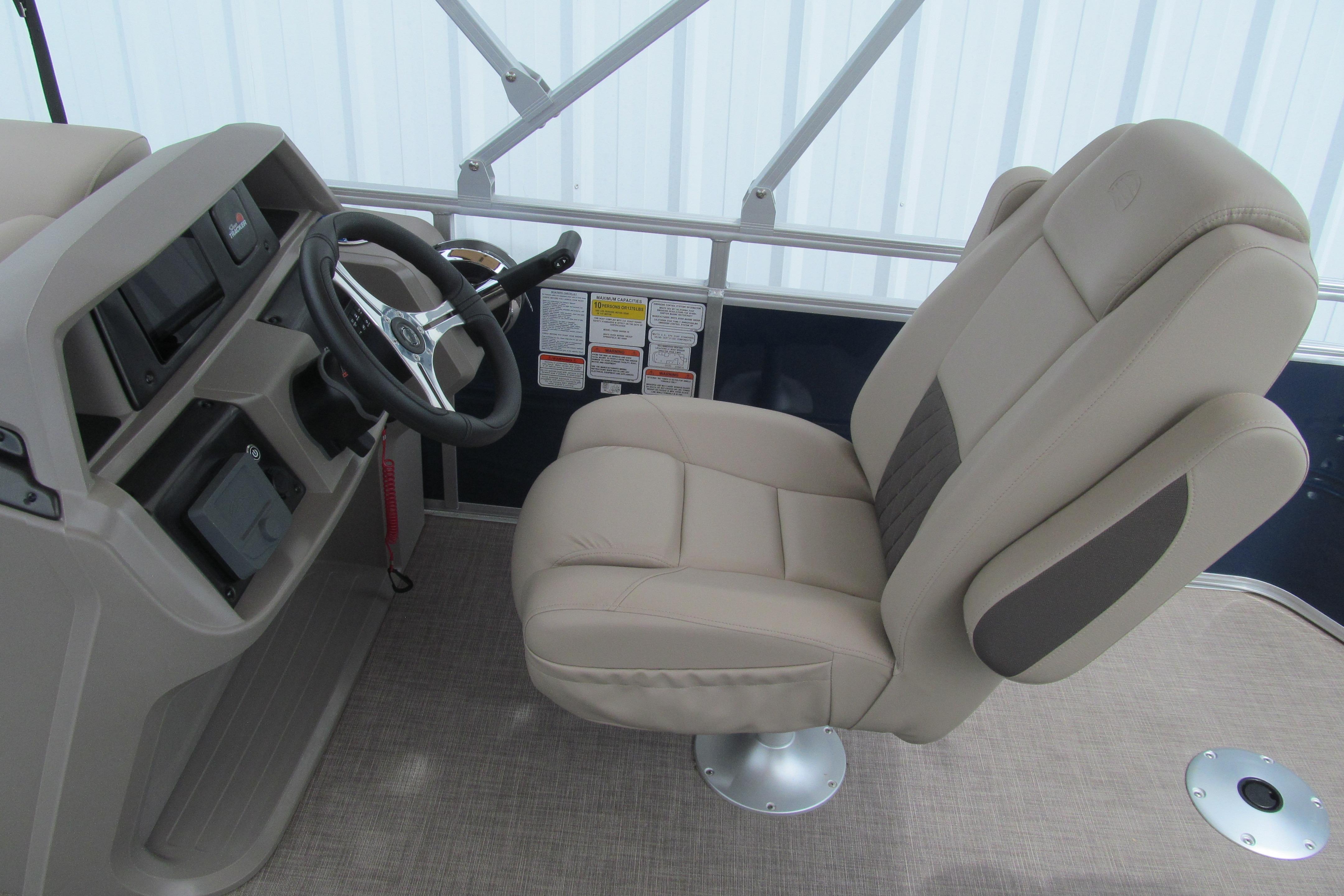 2024 Sun Tracker Fishin' Barge 20 DLX helm with beige captain's chair and steering wheel.