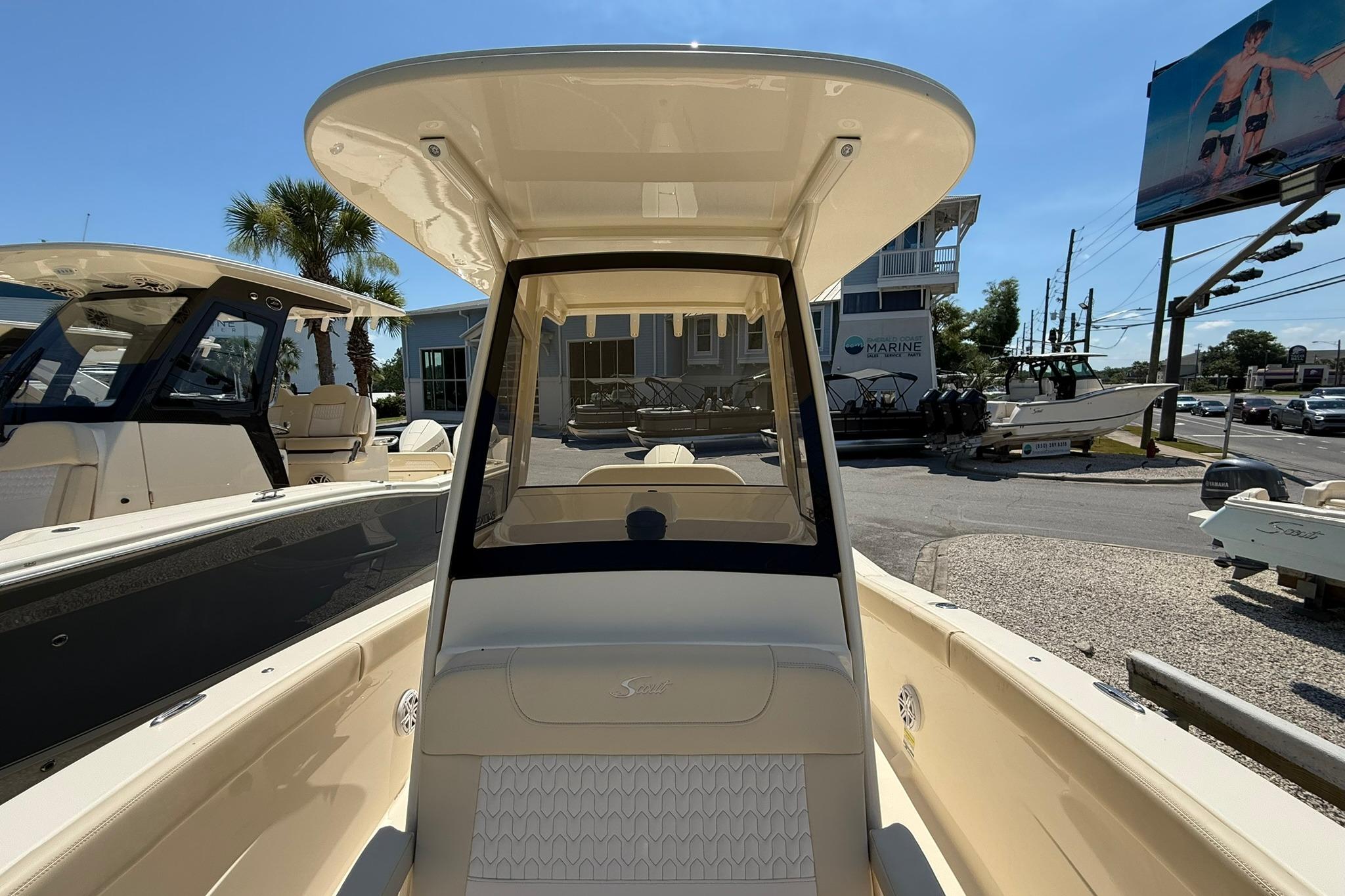 2027 Scout 240 XSF boat interior with helm, parked at a marina under clear skies.