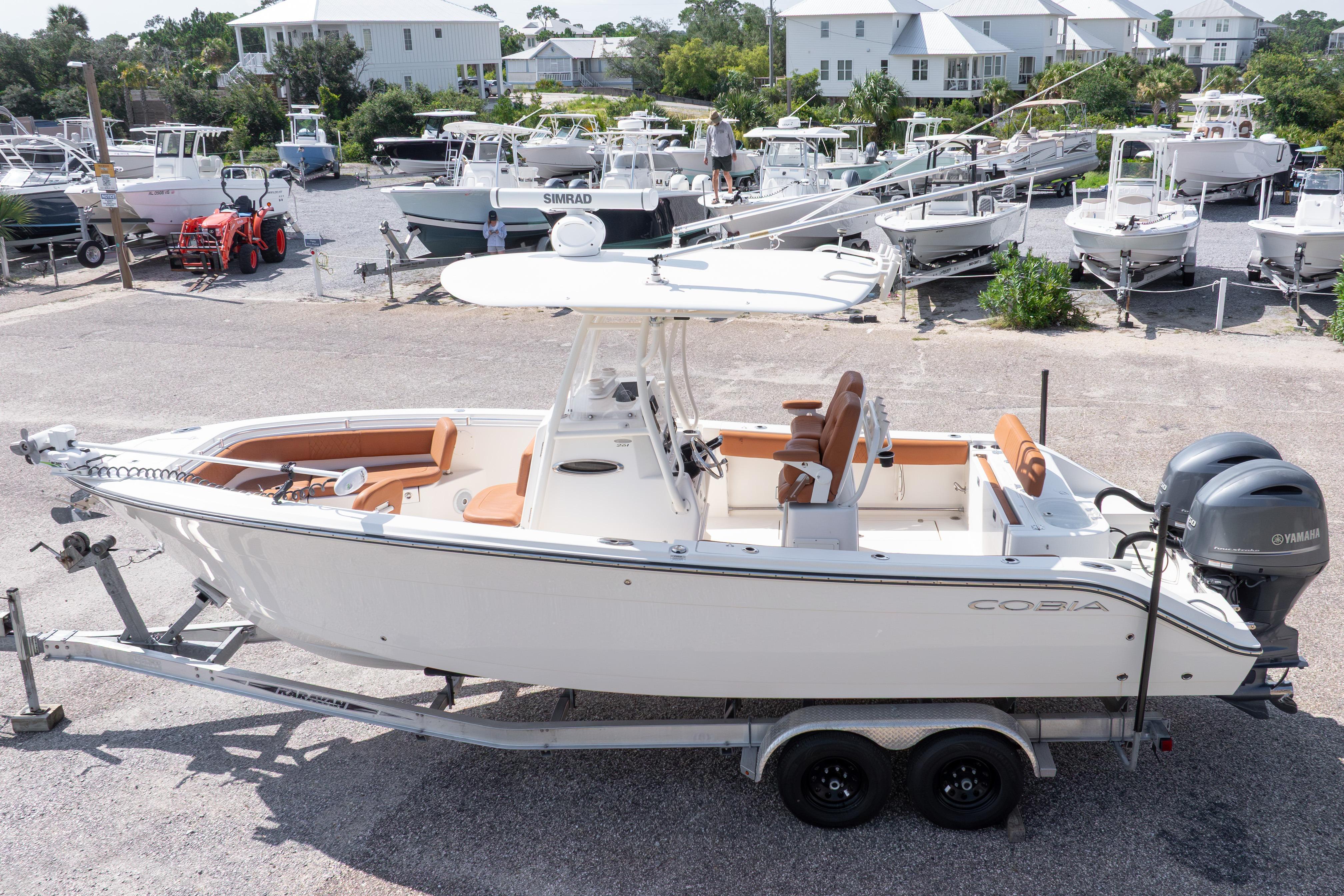 2017 Cobia 261 Center Console boat on trailer, parked in a marina with other boats.