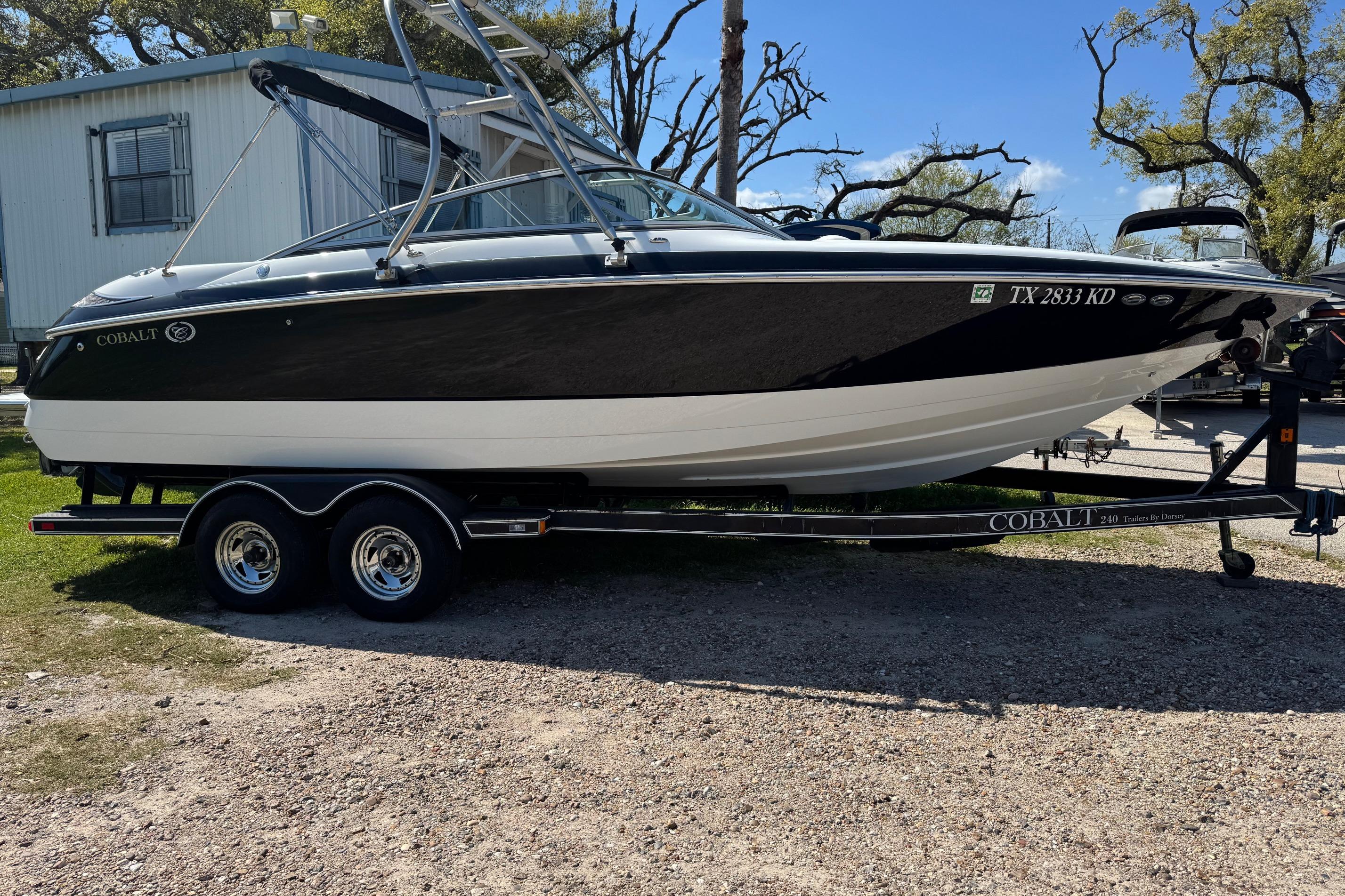 2005 Cobalt 240 boat on trailer, parked outdoors near a building.
