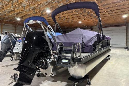 2026 Bennington 22SXSB pontoon boat in a spacious indoor storage facility.