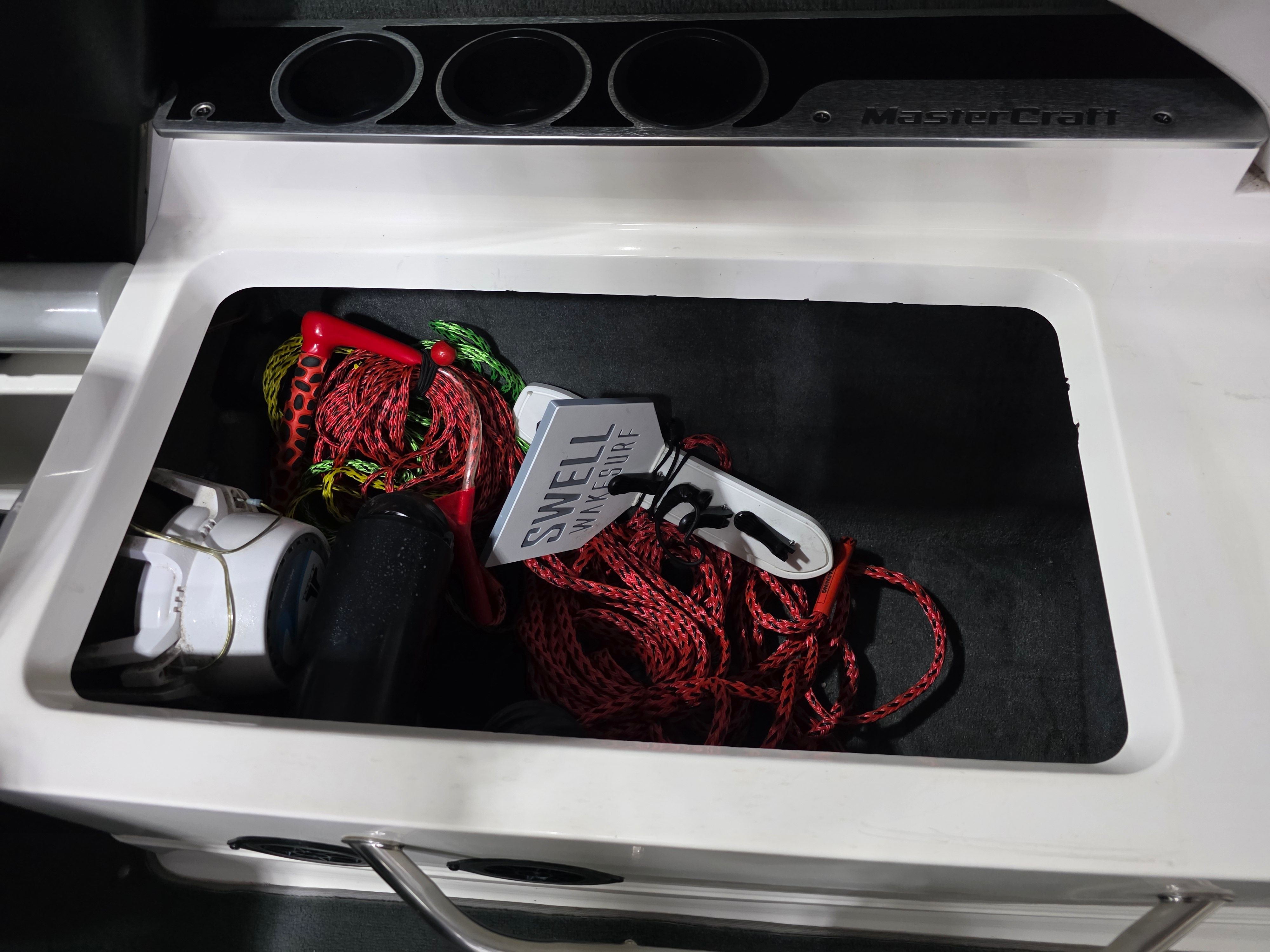 Storage compartment in MasterCraft X-15 boat with ropes and accessories.