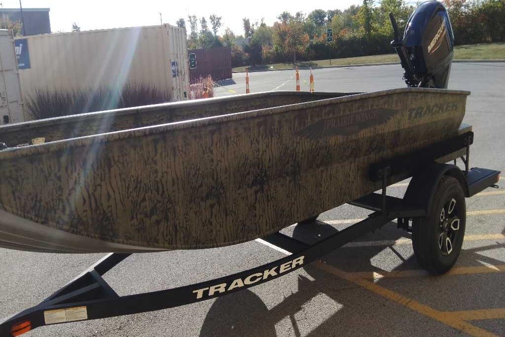 2026 Tracker Grizzly 1650 T Prairie Wings Edition boat on trailer in parking lot.