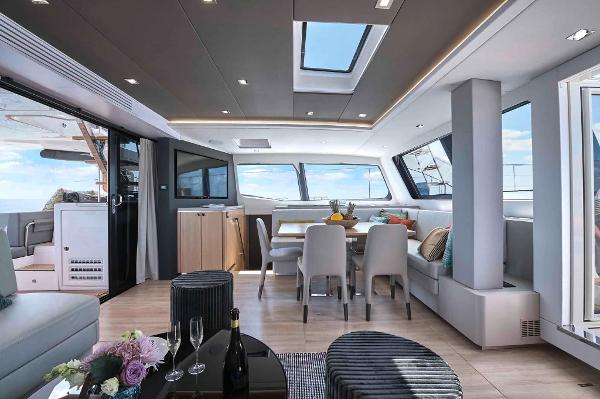 Luxurious interior of 2025 Privilege Signature 580 yacht with modern dining area and panoramic windows.