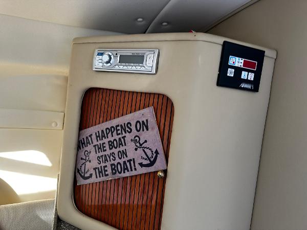 2004 Rinker Fiesta Vee 250 interior with humorous sign and control panel.