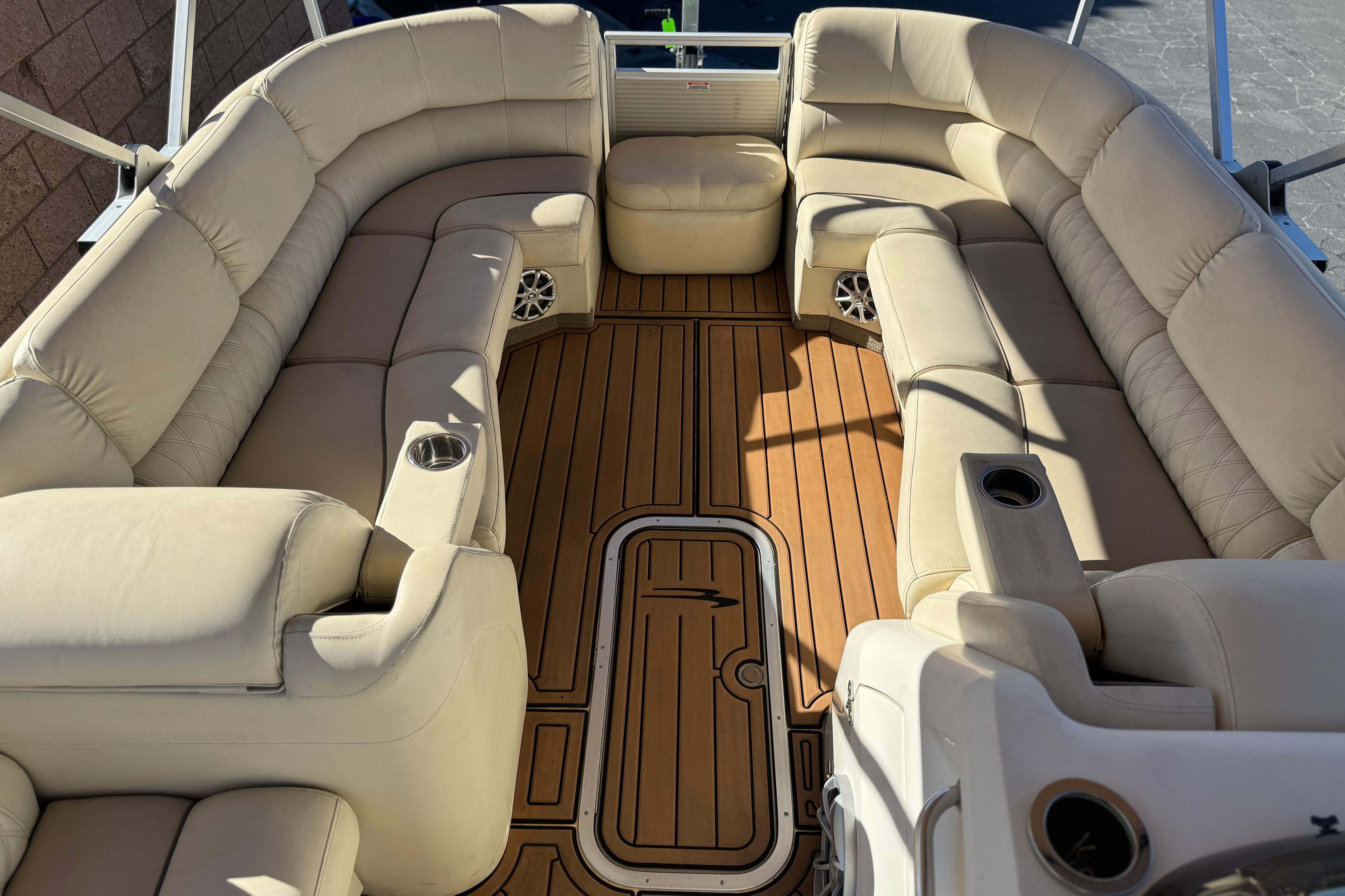 Luxurious interior of 2013 Bennington 2575QCW I/O boat with plush seating and wood flooring.