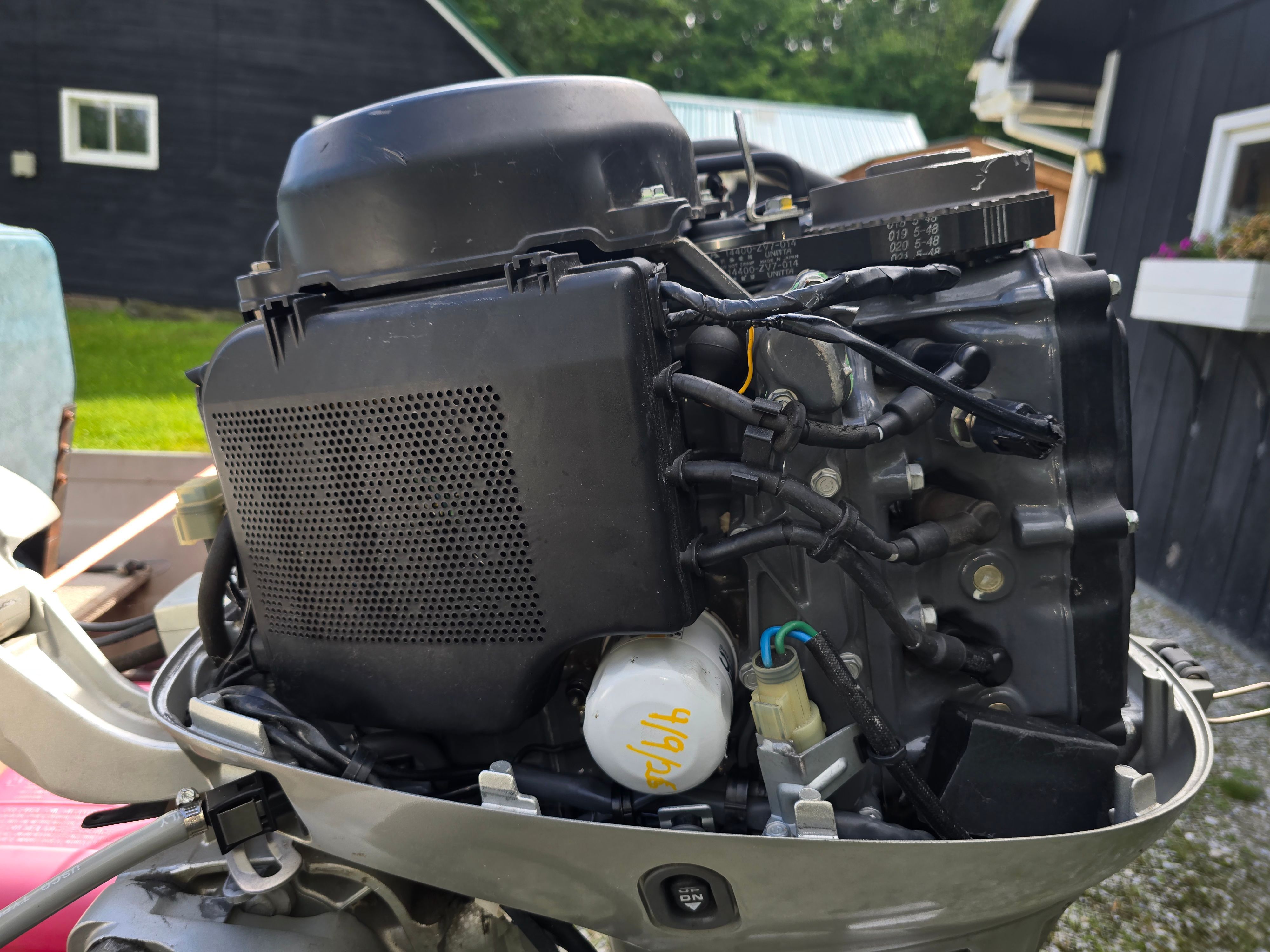 Close-up of a boat outboard motor with visible wires and components.