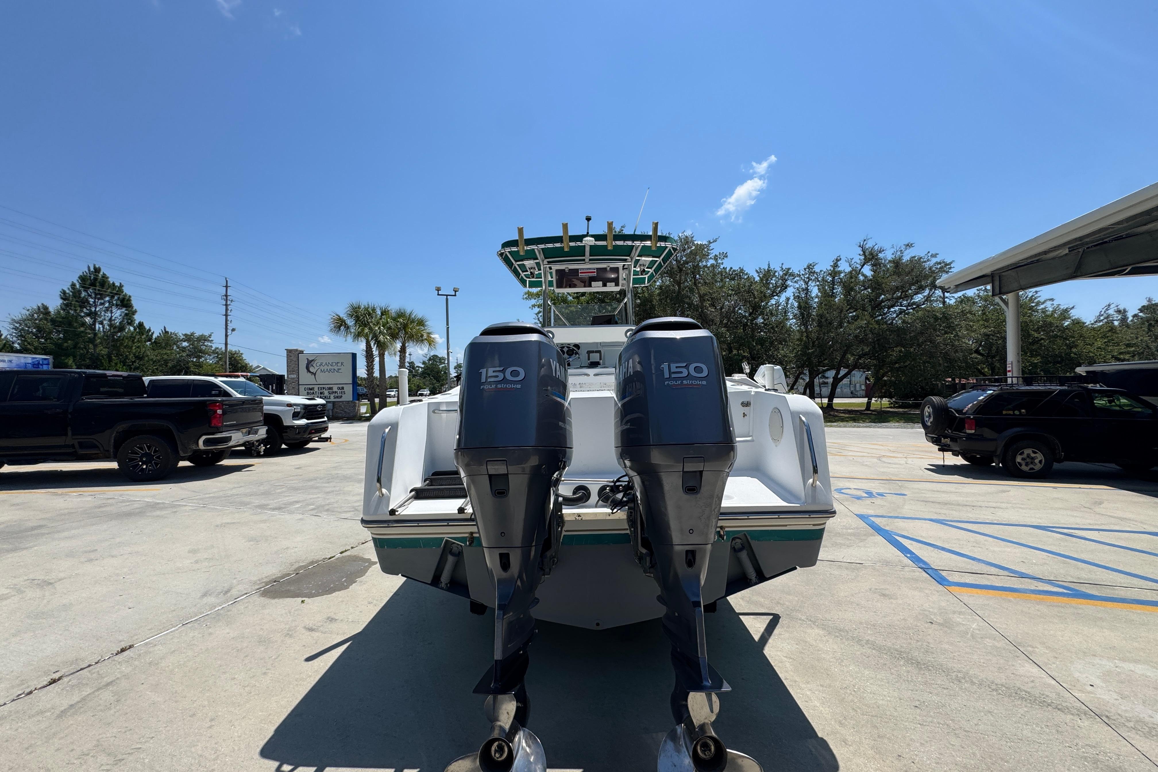 2000 Stamas 250 Tarpon boat with dual 150 horsepower engines in a parking lot.