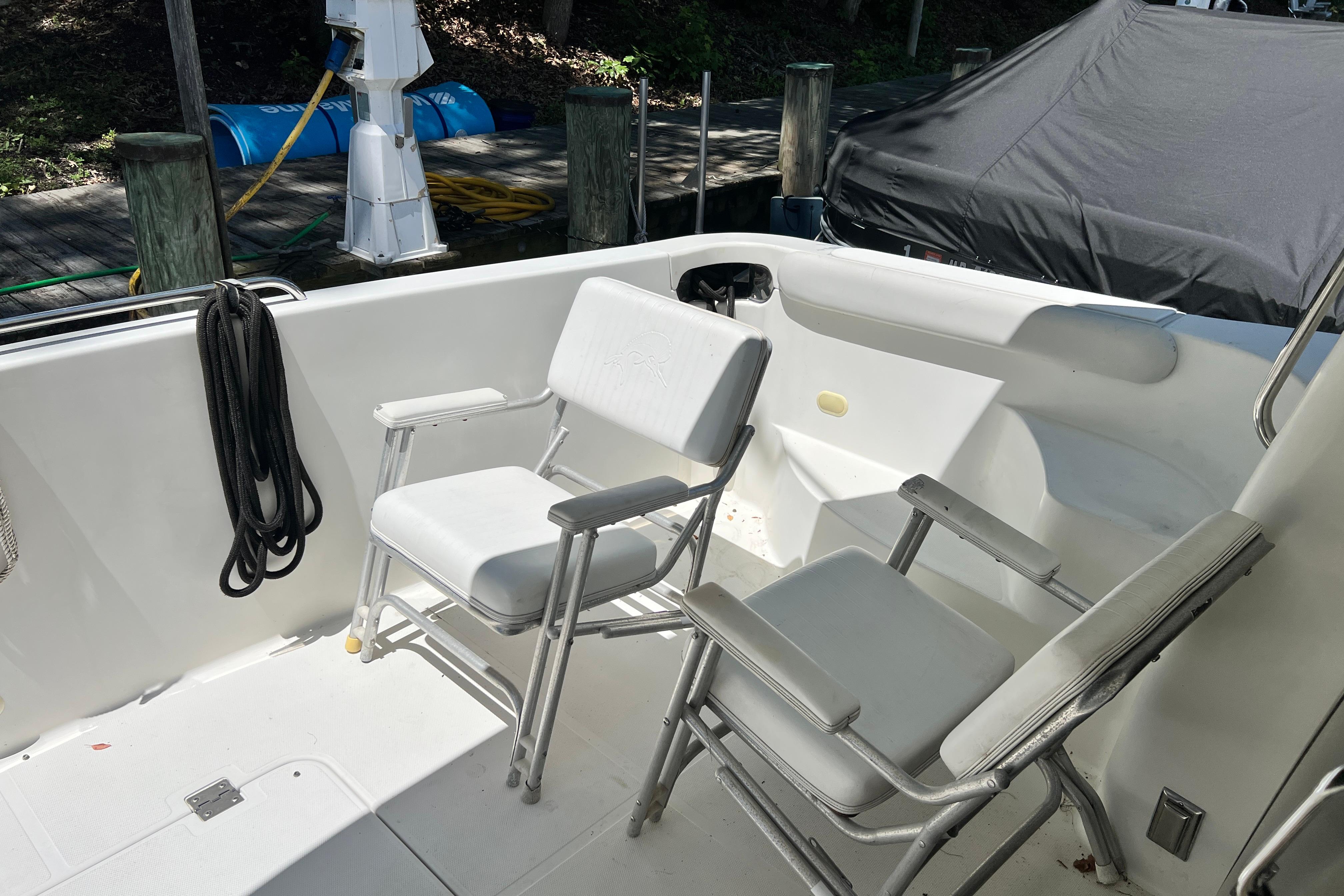 2003 Carver 450 Voyager Pilothouse deck with white chairs and dock view.