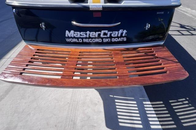 1996 MasterCraft ProStar 190 boat with wooden swim platform, showcasing "World Record Ski Boats" branding.