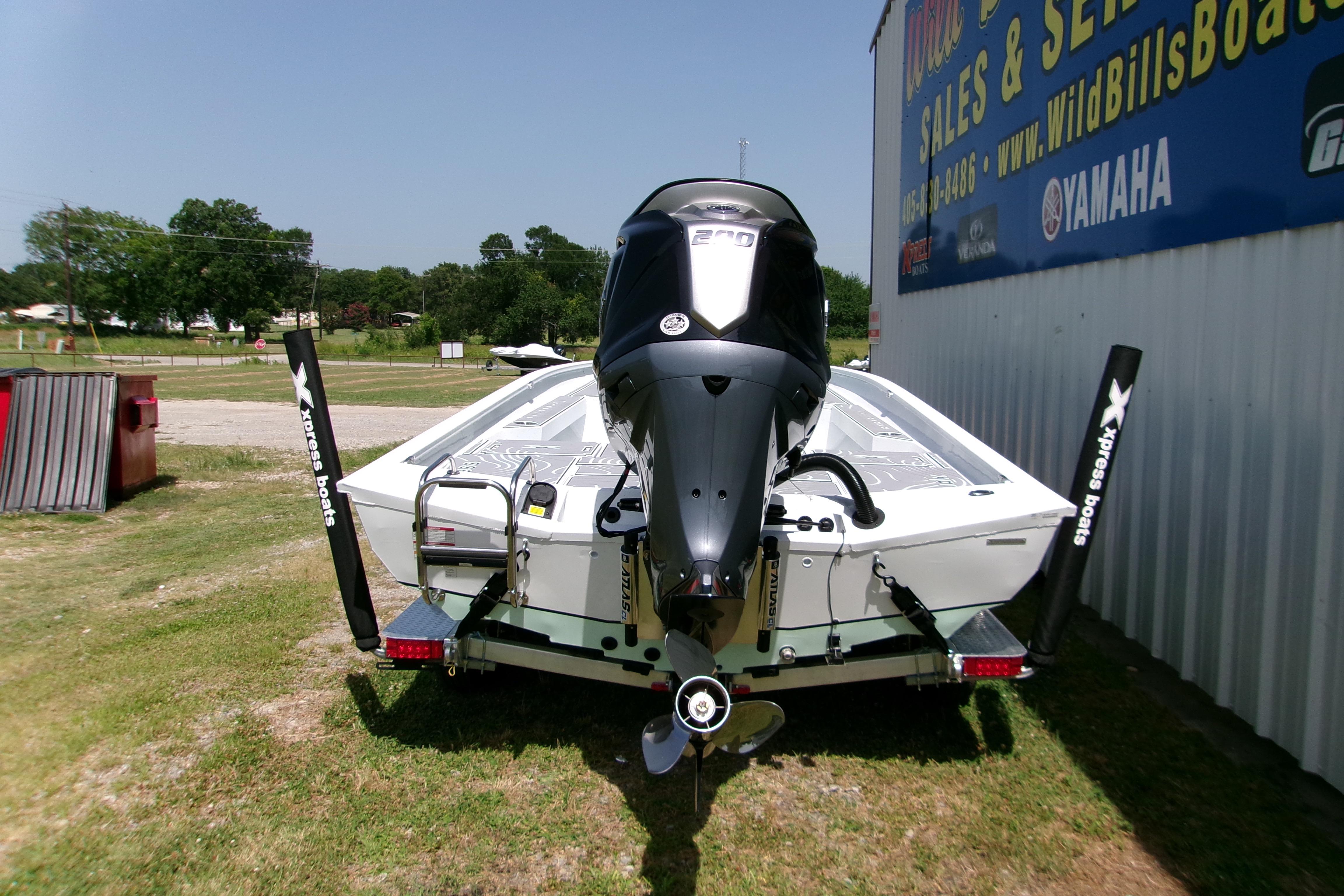 2027 Xpress H22B Bay boat with Yamaha engine, parked outdoors near dealership.