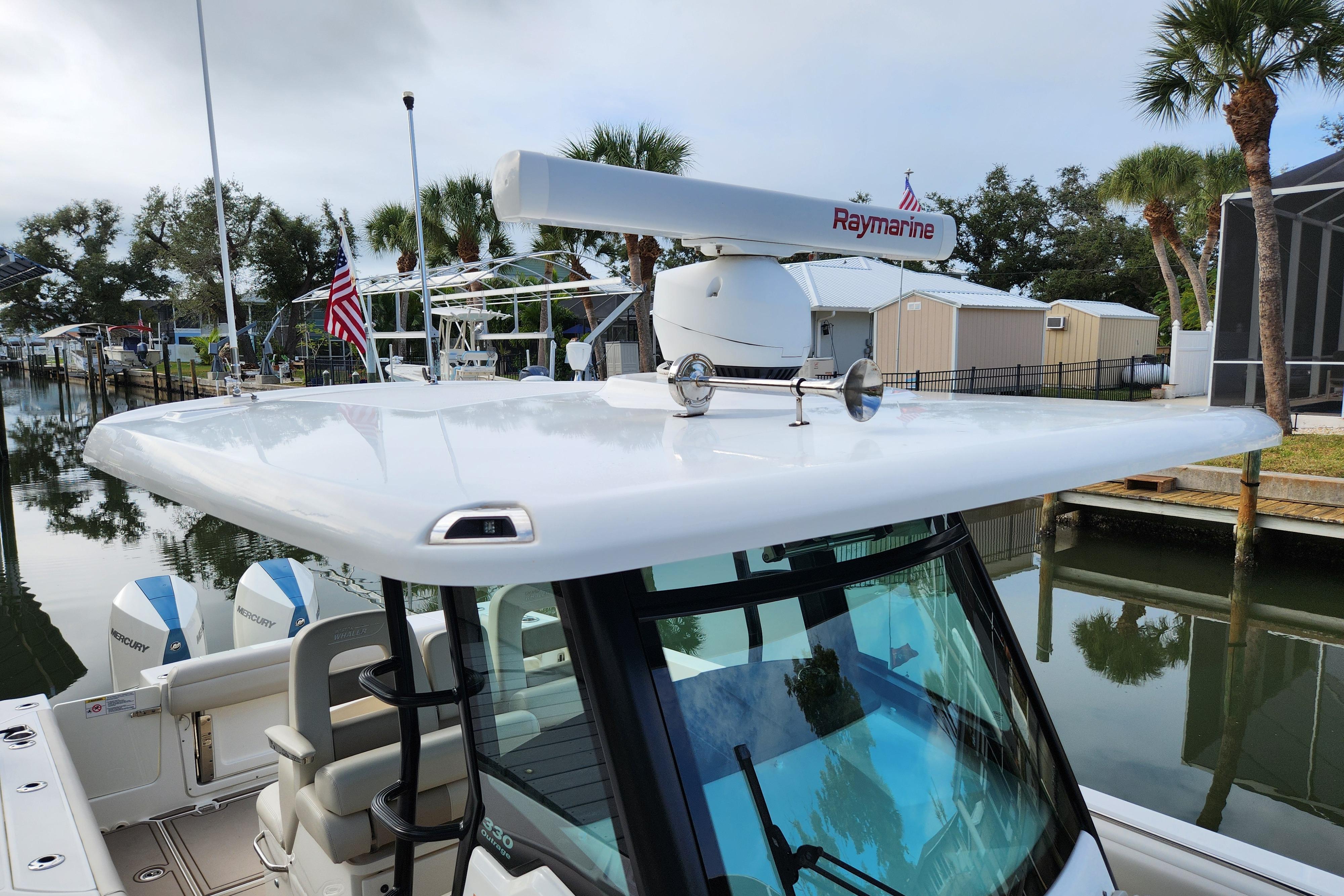 2022 Boston Whaler 330 Outrage boat with Raymarine radar, docked near palm trees.