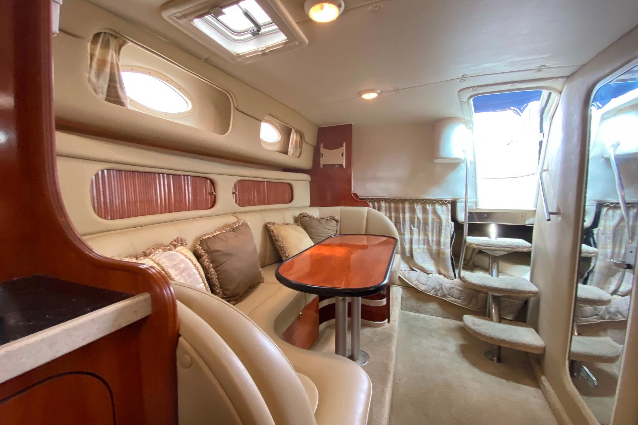 Interior of 2003 Rinker Fiesta Vee 342 yacht with cozy seating and elegant wood finishes.