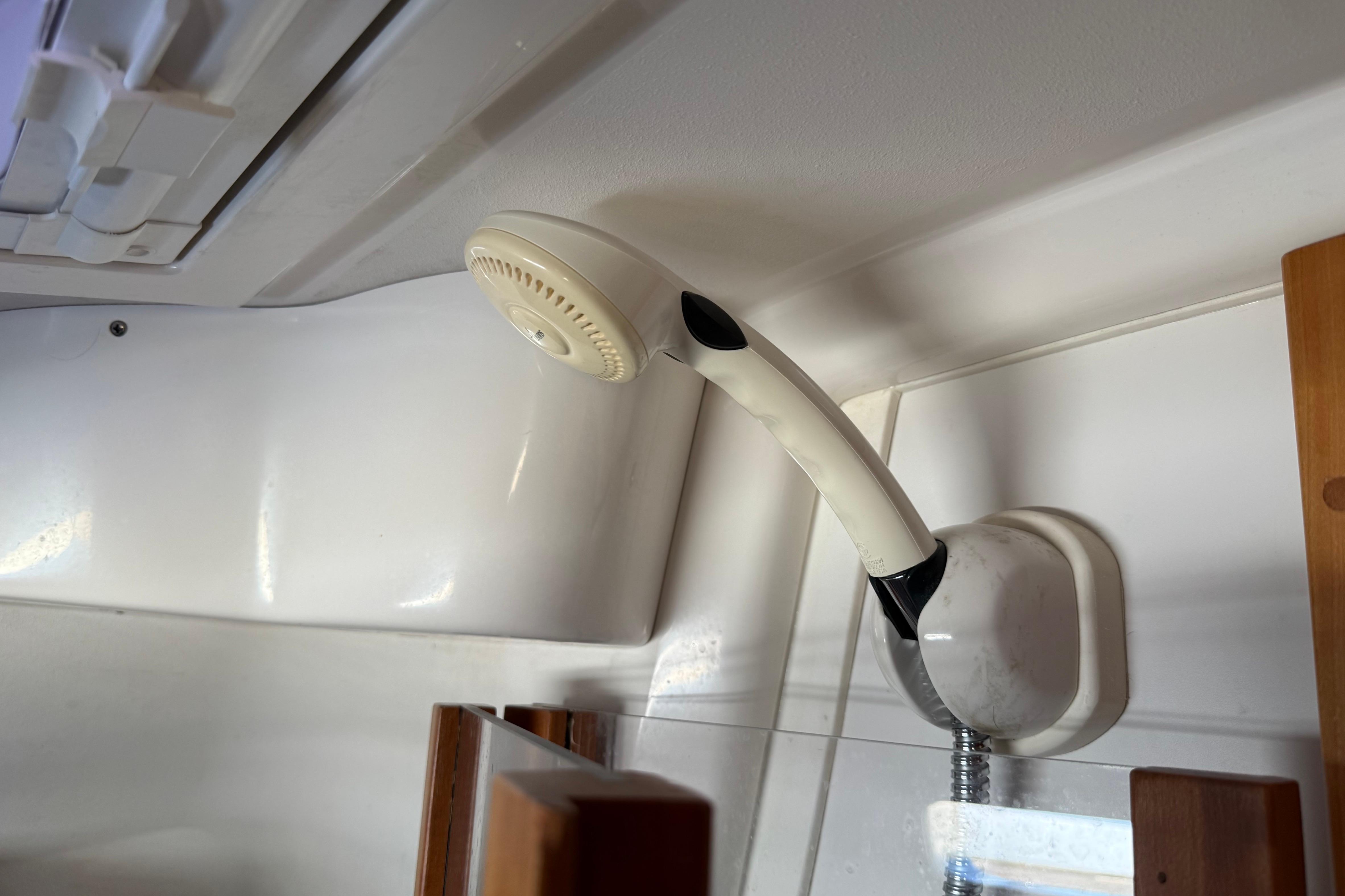 Showerhead in a 2004 Sabre 386 boat interior, mounted on a white wall.