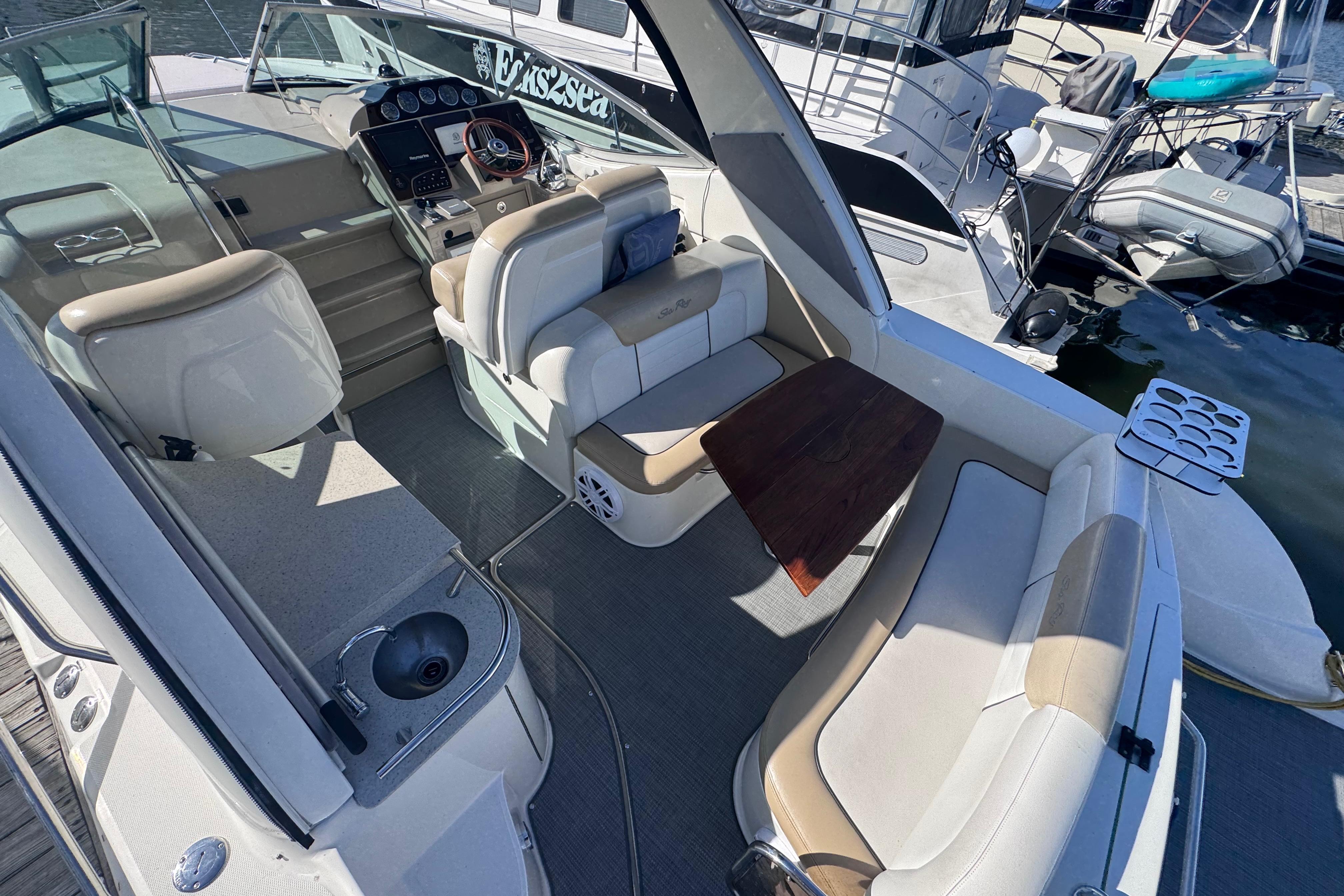 2008 Sea Ray 350 Sundancer boat interior with seating, table, and helm at marina.