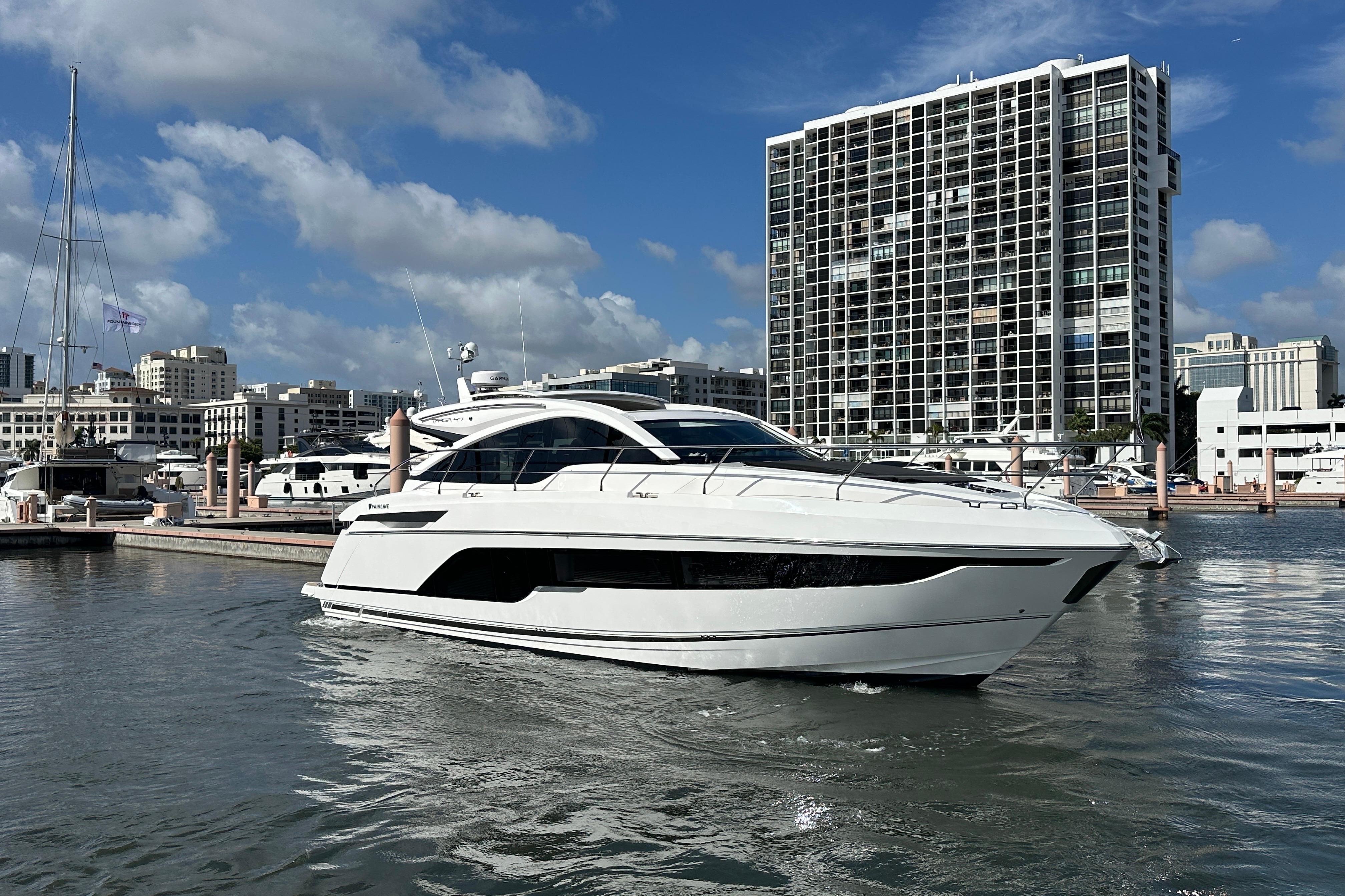 2026 Fairline Targa 47 GT yacht docked in urban marina, modern cityscape background.