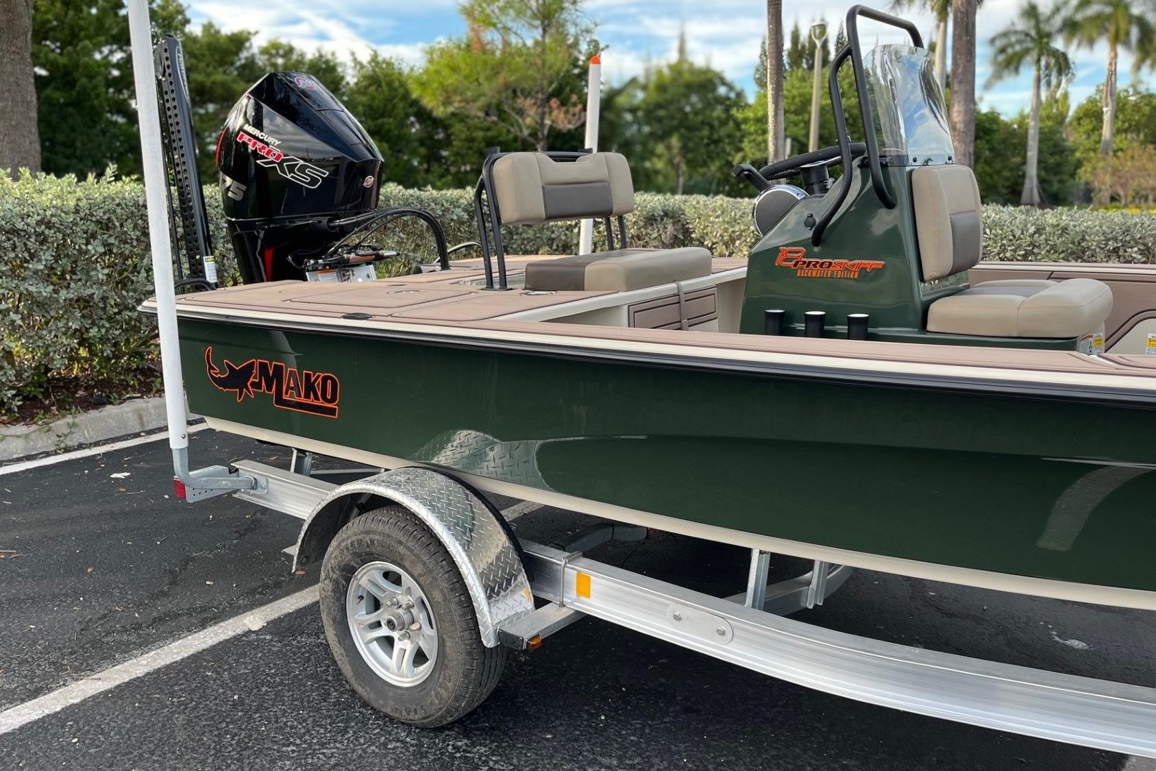 2026 Mako 18 Pro Skiff Backwater Edition boat on trailer, parked outdoors.