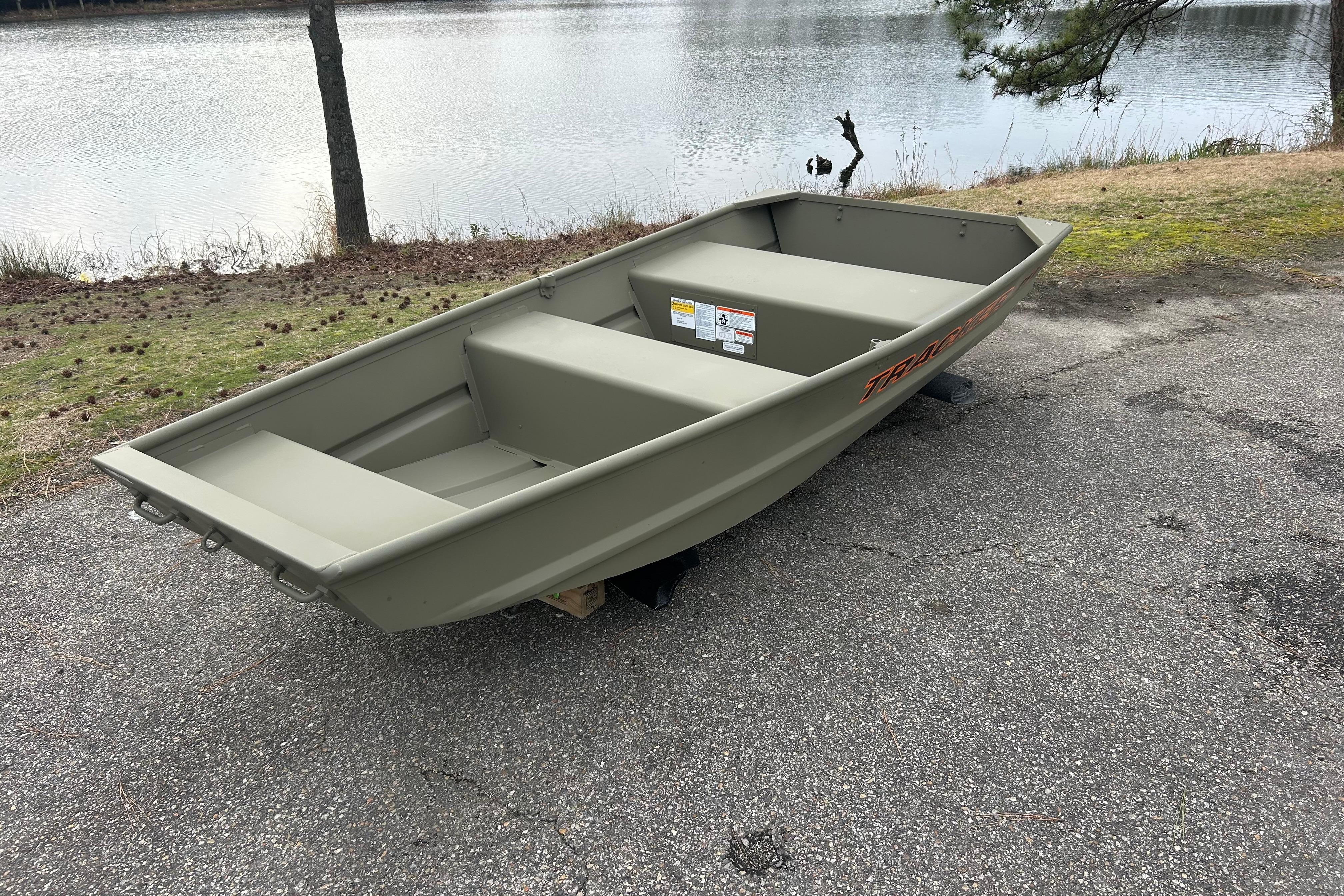 2026 Tracker Grizzly 10 Jon boat on lakeside pavement, showcasing durable design and spacious interior.