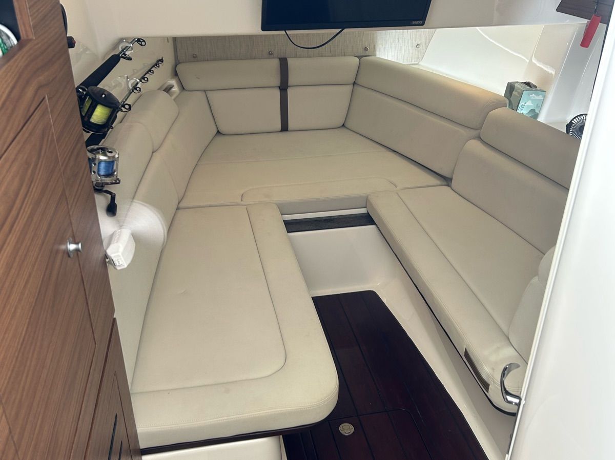 Interior of the 2021 Boston Whaler 350 Realm with beige upholstery and wooden flooring.