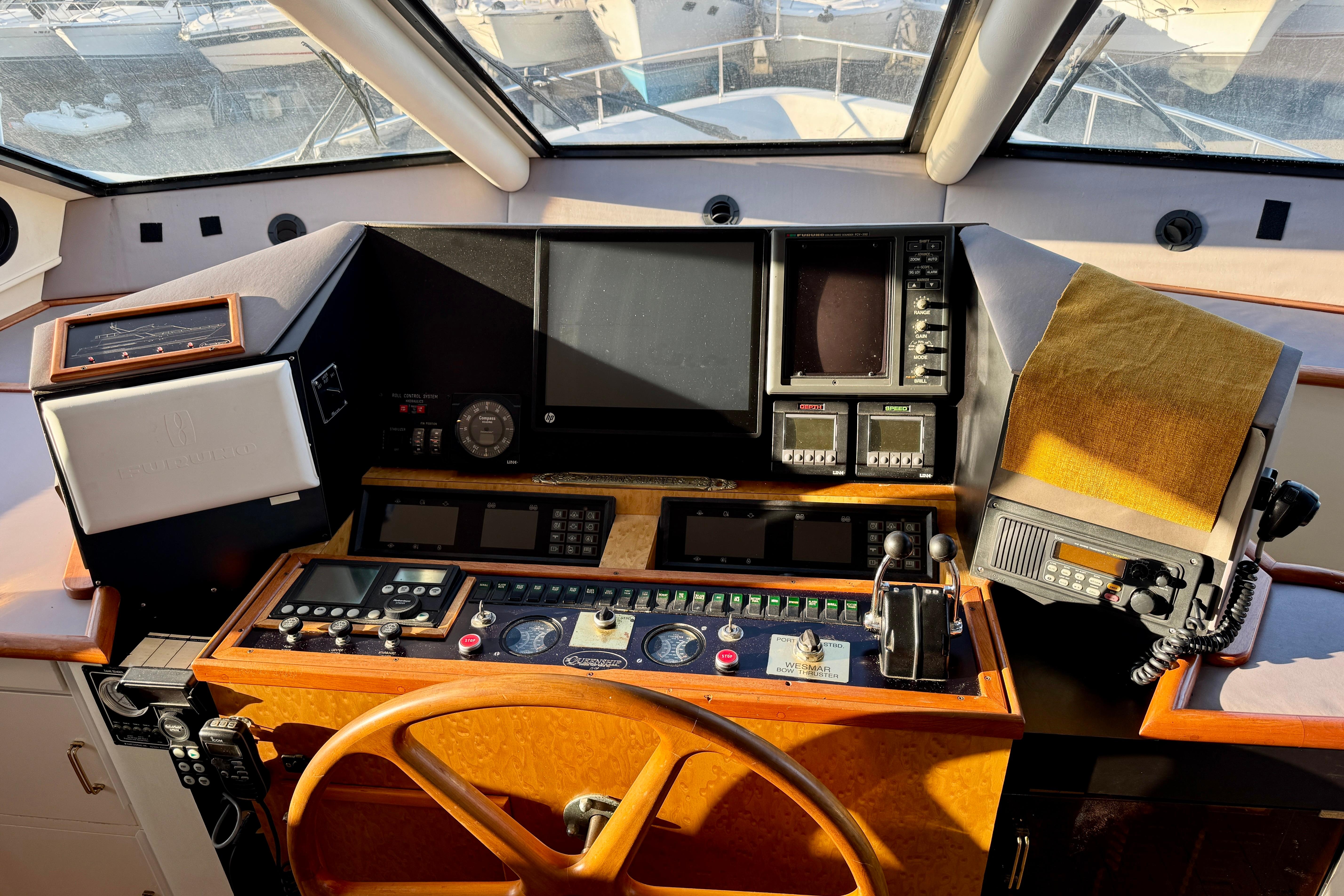 Pilothouse of 1995 Queenship 62 Motor Yacht with navigation controls and steering wheel.