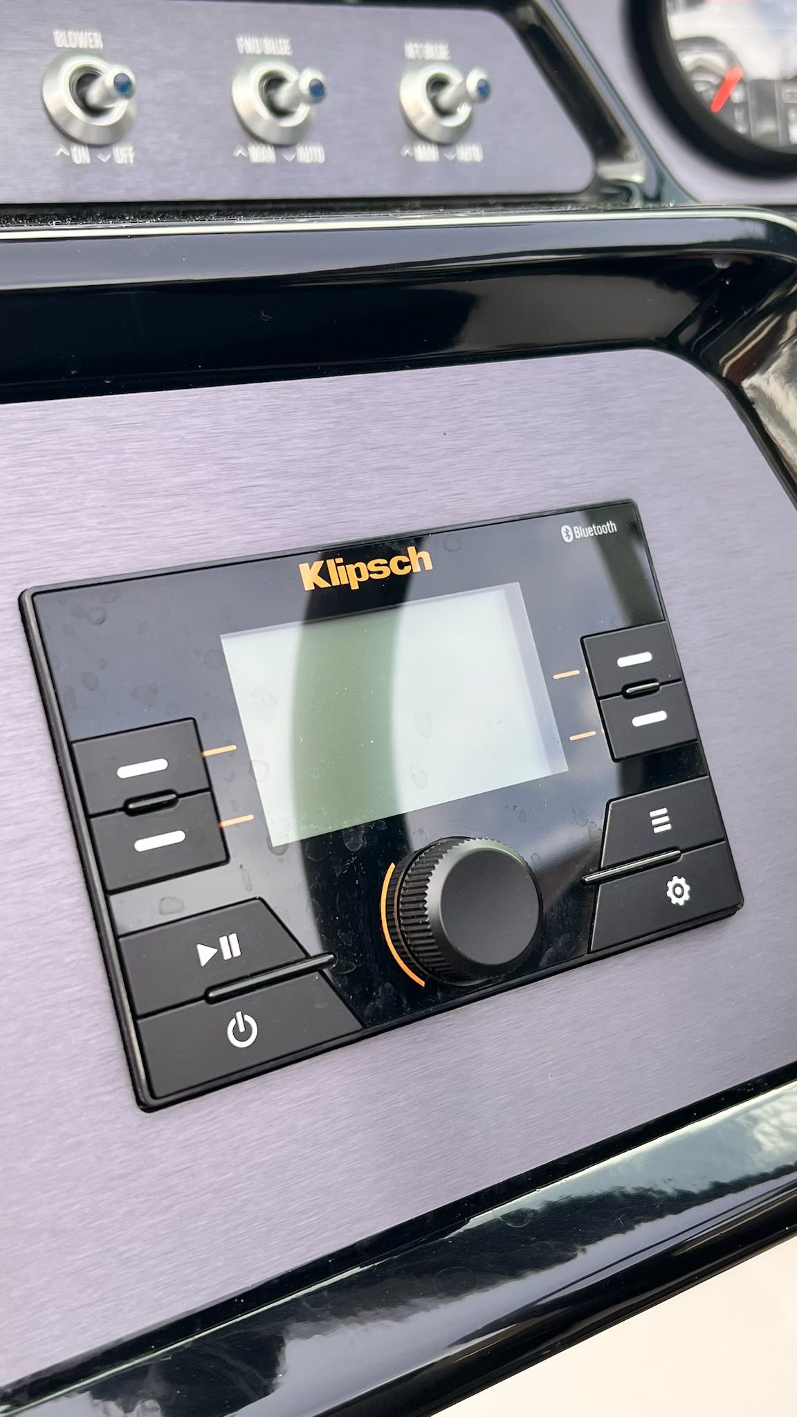 The image shows a Klipsch control panel on a boat, surrounded by switches and gauges.