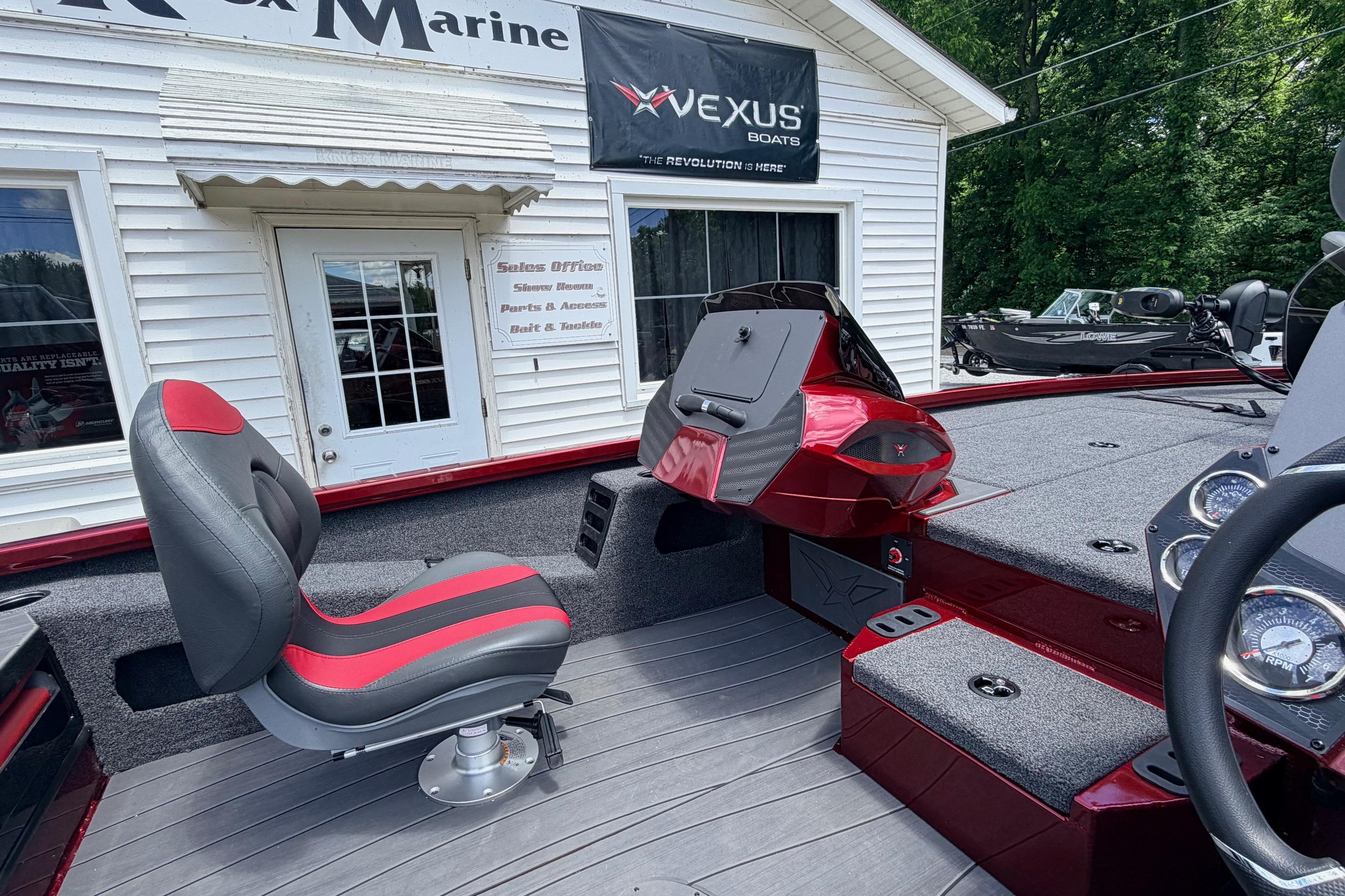 2026 Vexus AVX1985s boat interior with red and gray seating, displayed at a marine dealership.