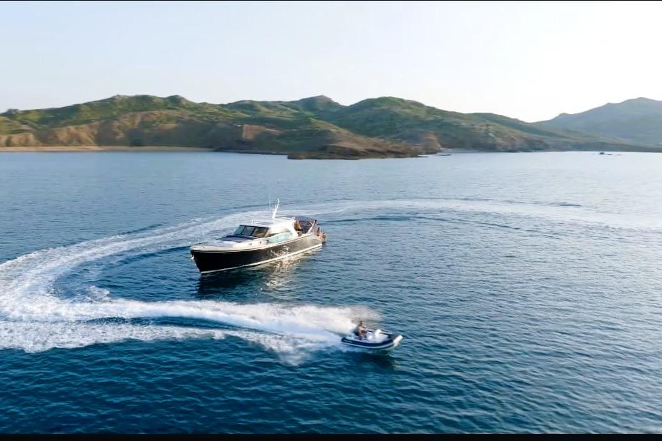 2009 Franchini Emozione yacht cruising with jet ski in scenic coastal waters.