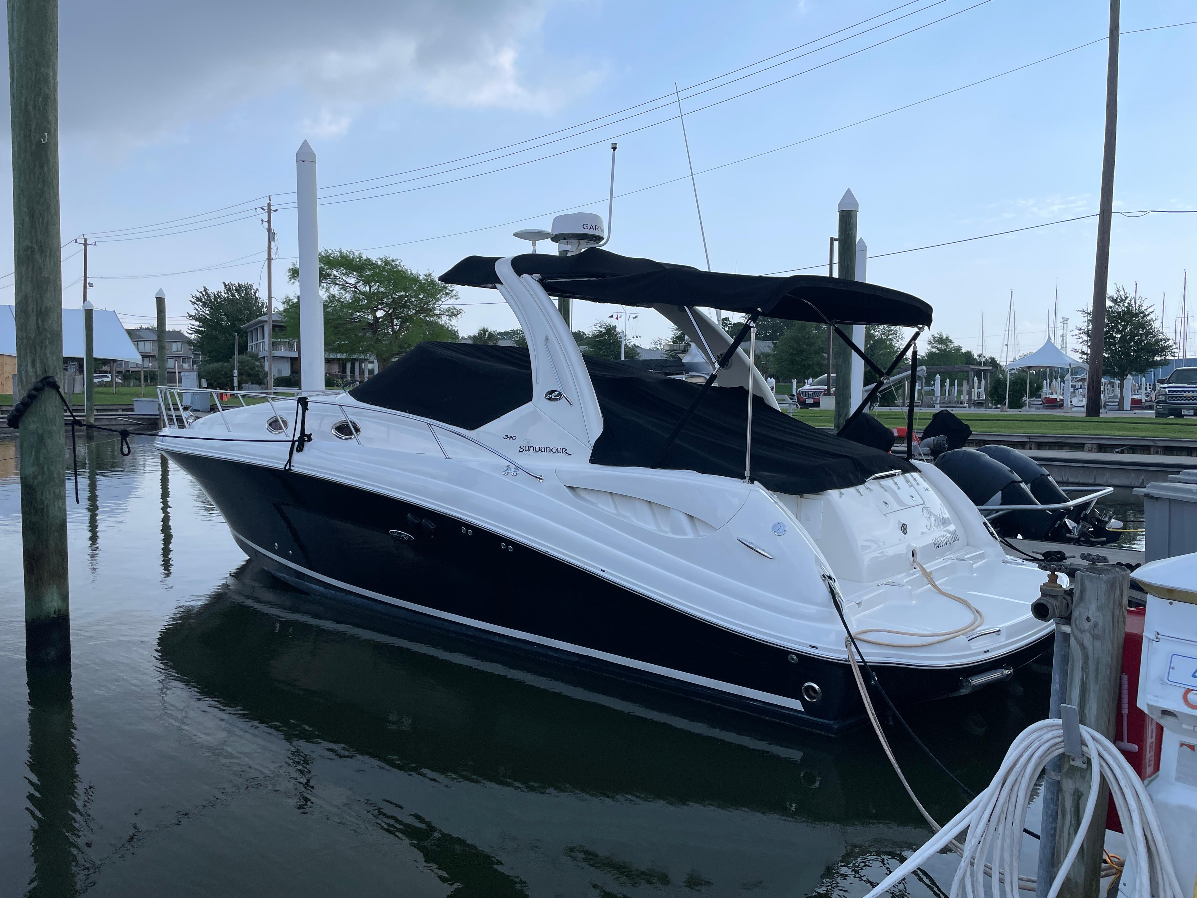 2007 Sea Ray 340 Sundancer boat docked at marina, featuring sleek black and white design.
