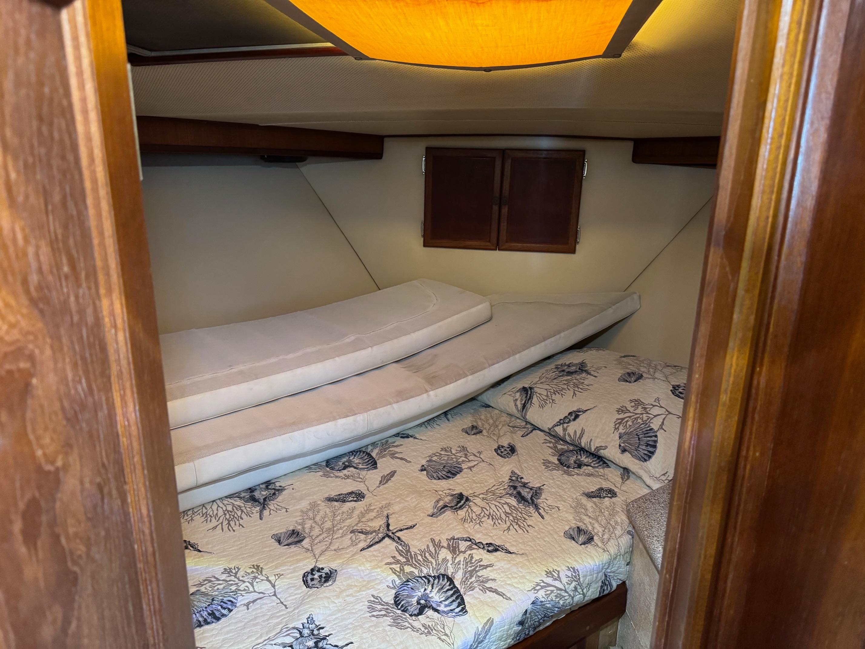 Cozy cabin interior of 1982 Viking 46 Convertible with nautical-themed bedding.