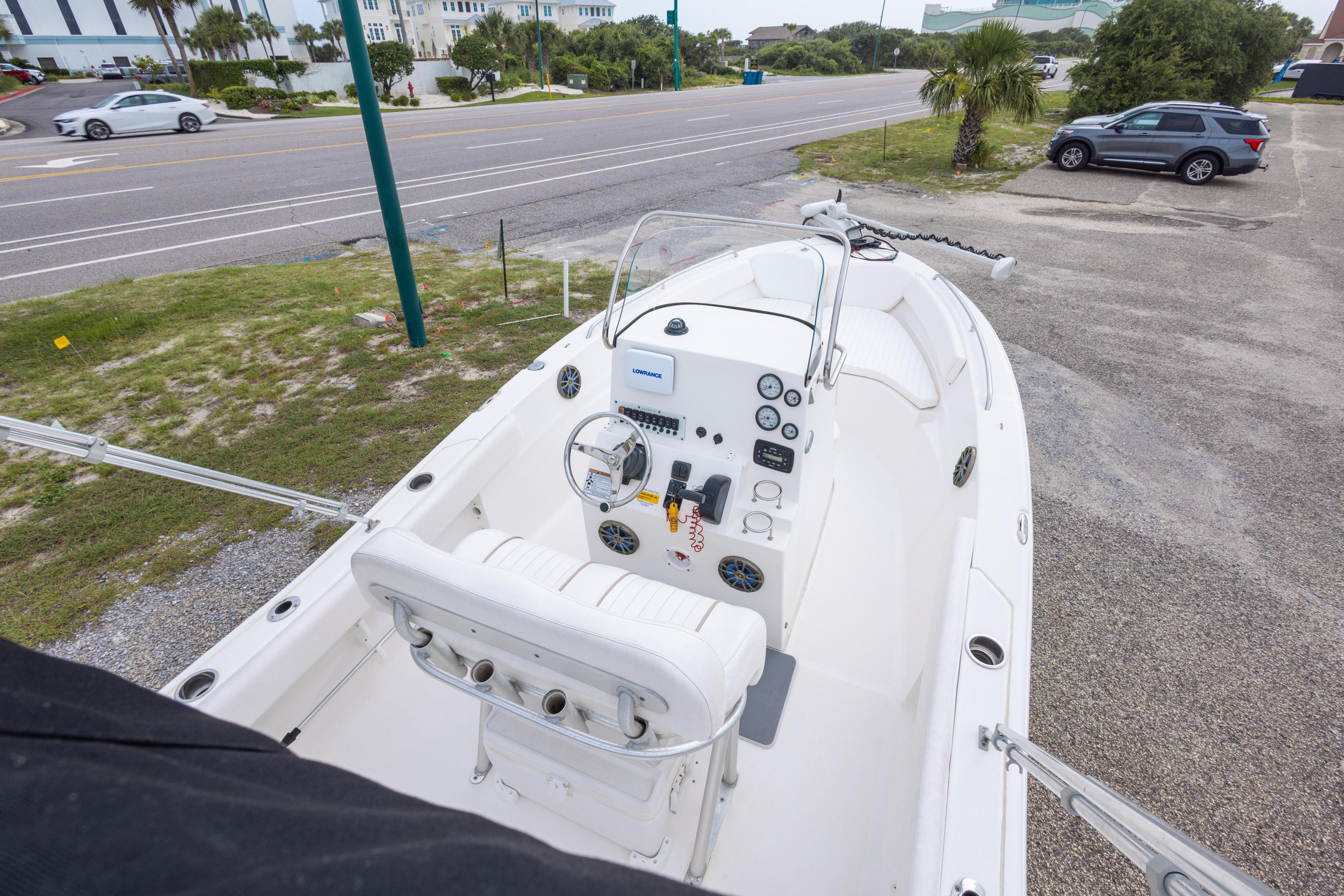 2014 Sea Fox 209 Commander boat parked near a road, showcasing its helm and seating area.