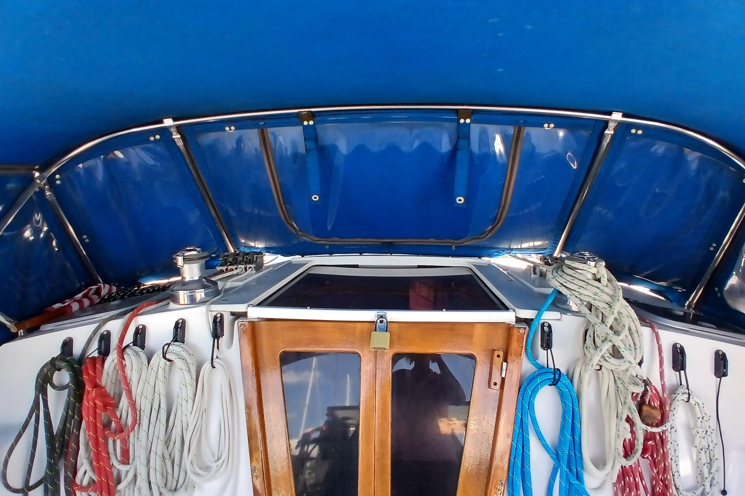 Cockpit of 1995 Catalina 42 MkII sailboat with ropes and blue canopy.