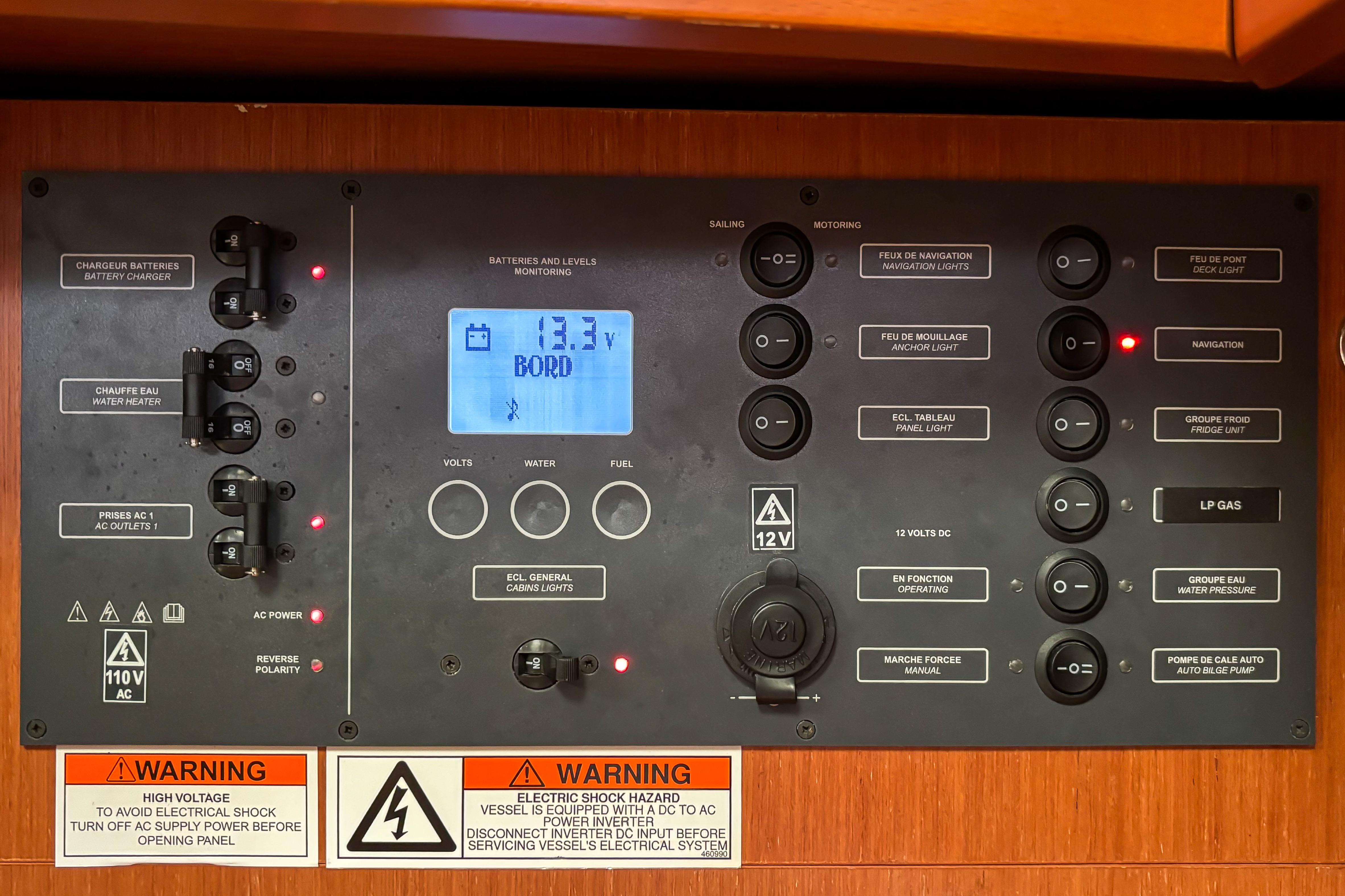 Electrical control panel on a 2015 Beneteau Oceanis 37 sailboat, displaying voltage and warnings.