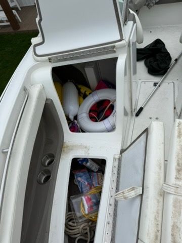 A 2001 Cobalt 226 with open storage compartments showing life rings and ropes.