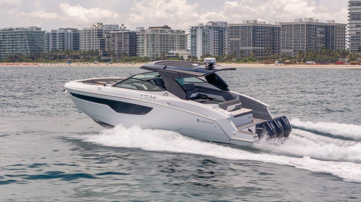 2021 Cruisers Yachts 38 GLS cruising near city skyline on open water.