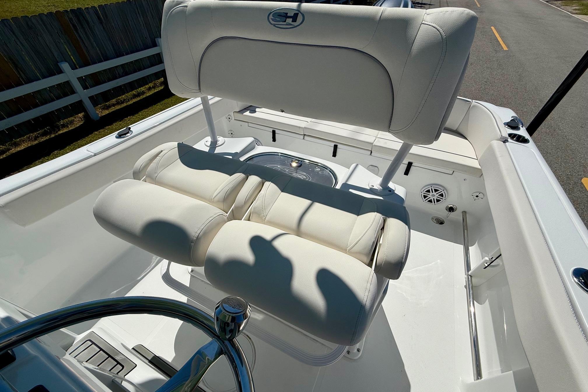 2026 Sea Hunt Ultra 229 boat interior with white cushioned seating and steering wheel.