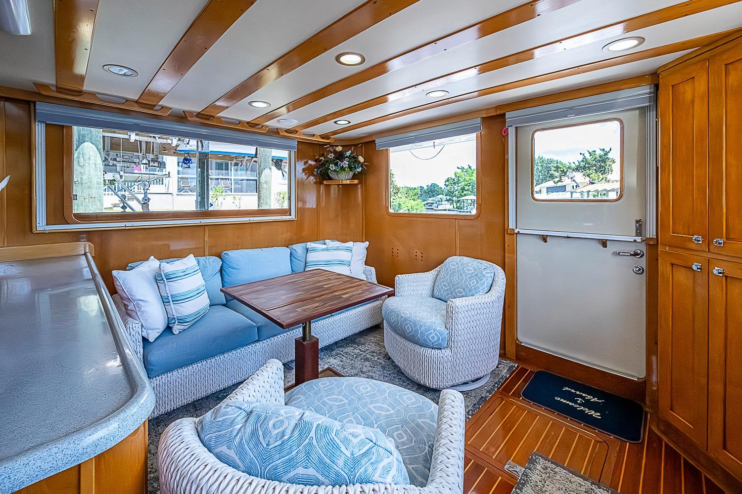 Luxurious interior of 2003 Magna Marine Nova Scotia 47 yacht with cozy seating and wooden accents.