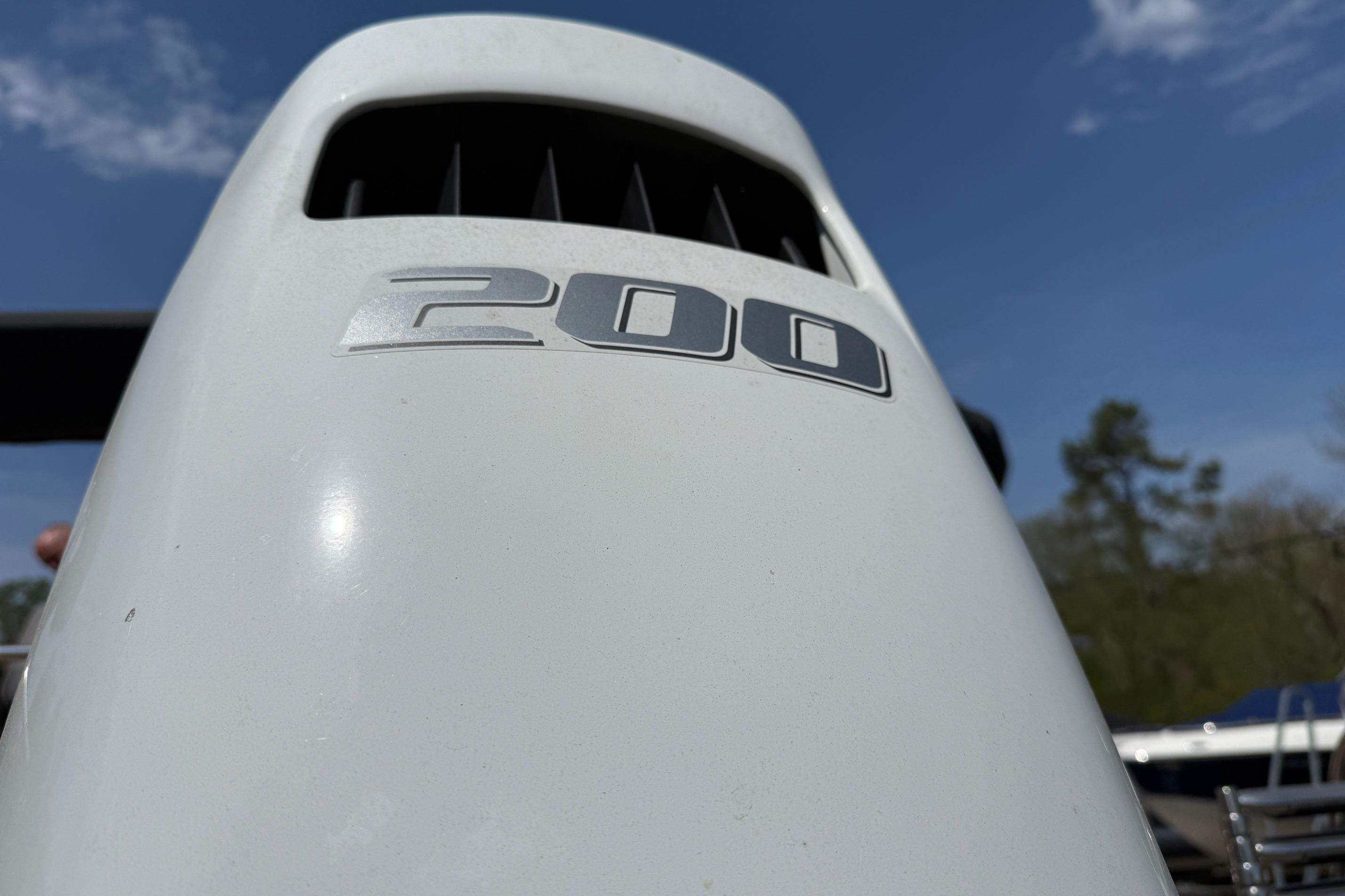 Close-up of Sylvan X1 CLZ DH 2024 outboard motor with "200" label under blue sky.