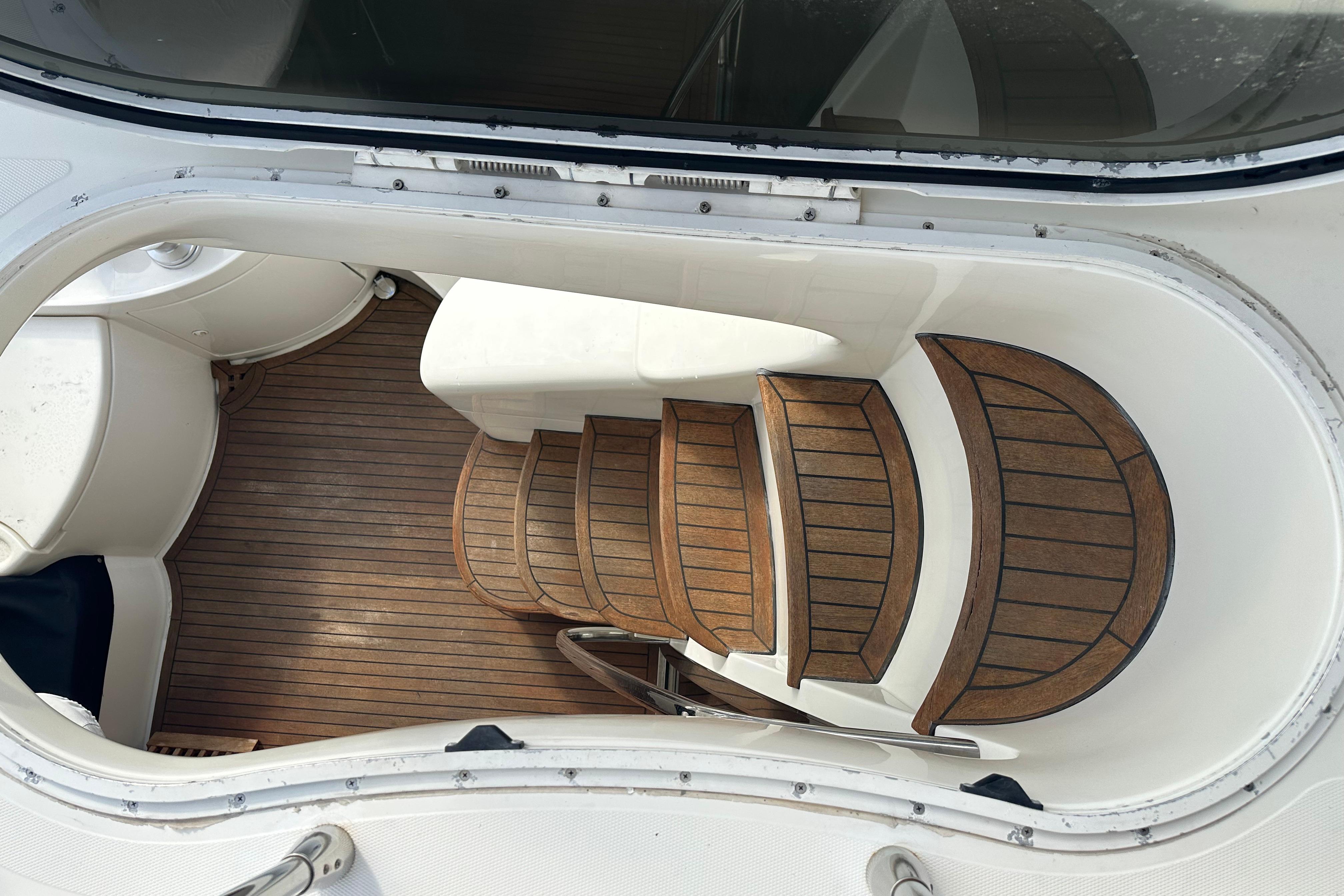 Staircase on 2004 Azimut 55E yacht with wooden steps and white interior.