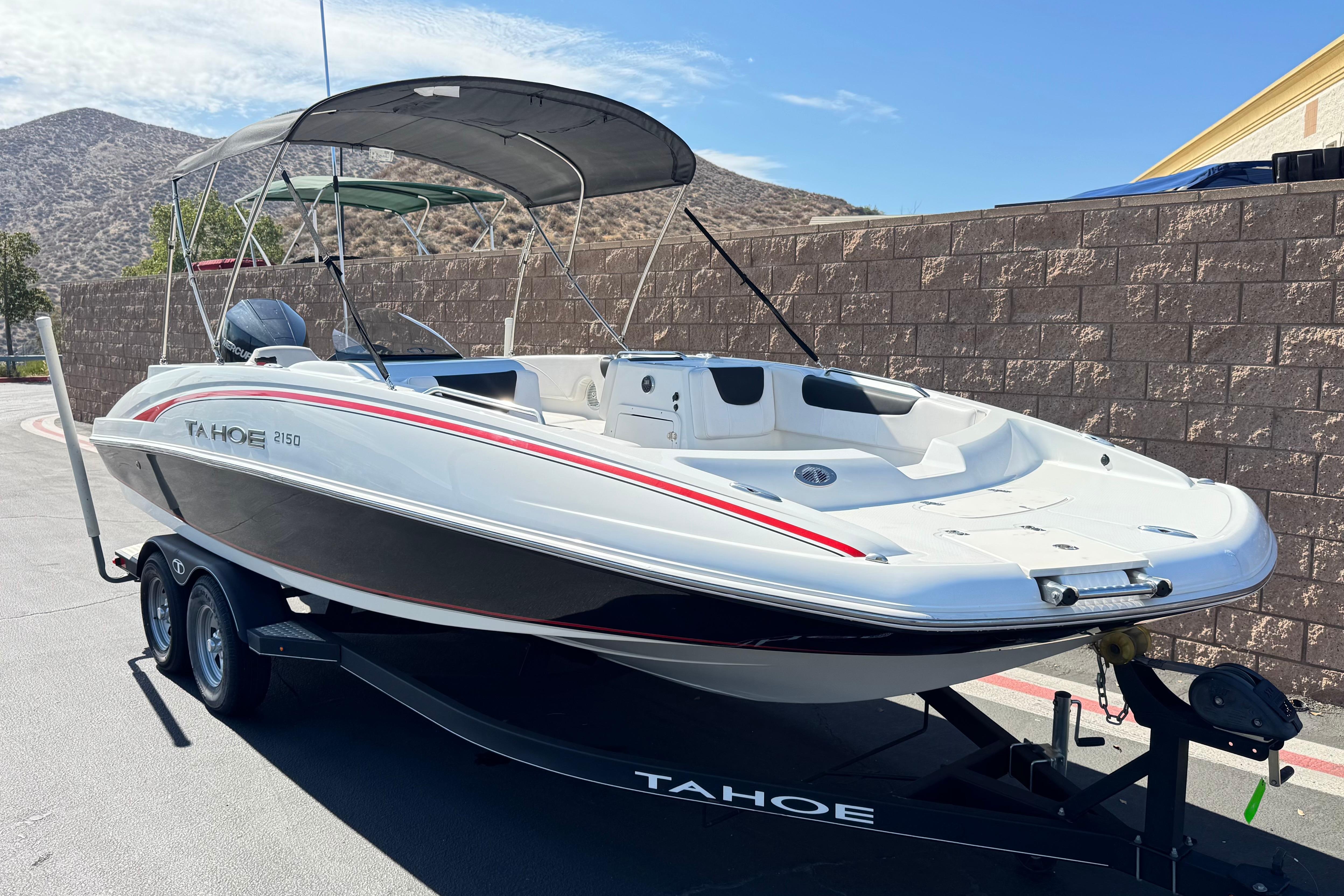 2019 Tahoe 2150 boat on trailer, parked outdoors with mountains in background.